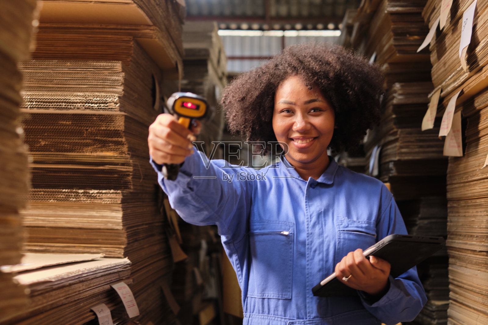 一名女工在包裹仓库工厂扫描条形码检查订单。照片摄影图片