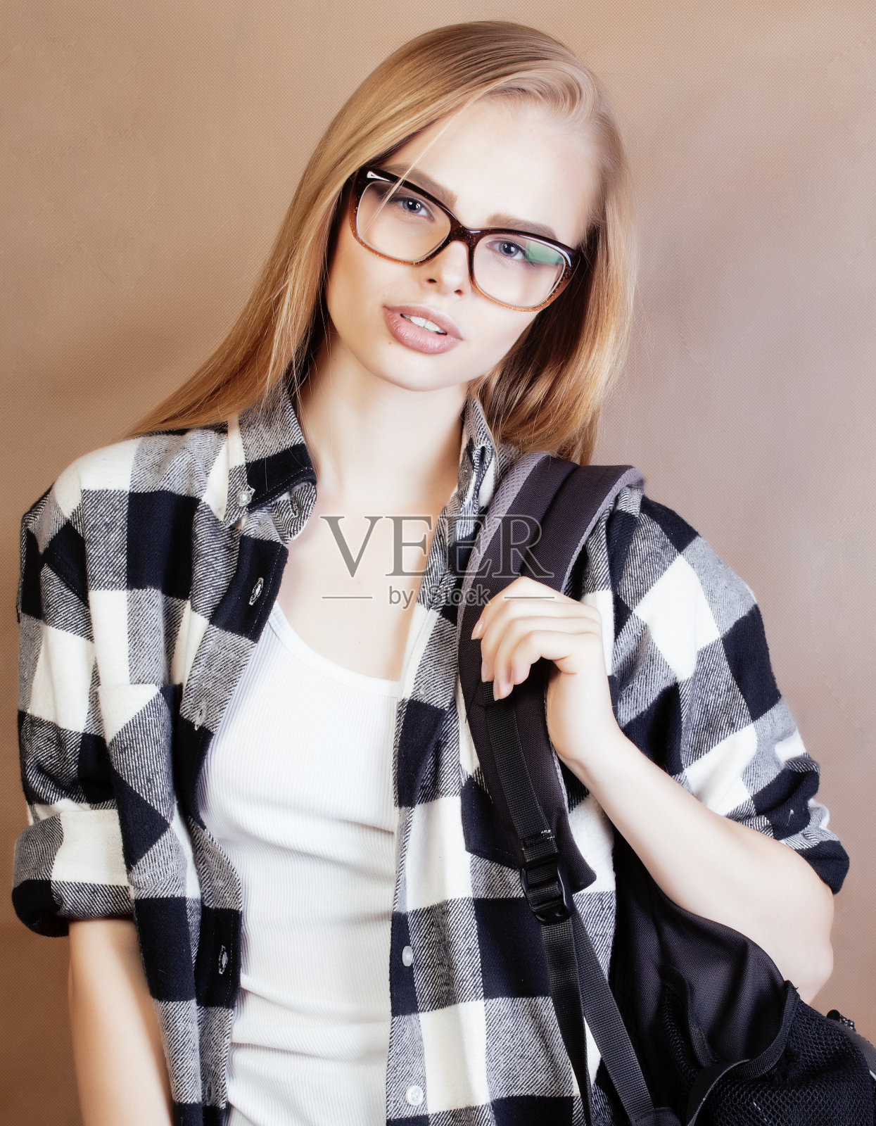 年轻漂亮的女孩十几岁,戴着眼镜在学校自拍,背着背包的学生,生活方式和人的概念照片摄影图片