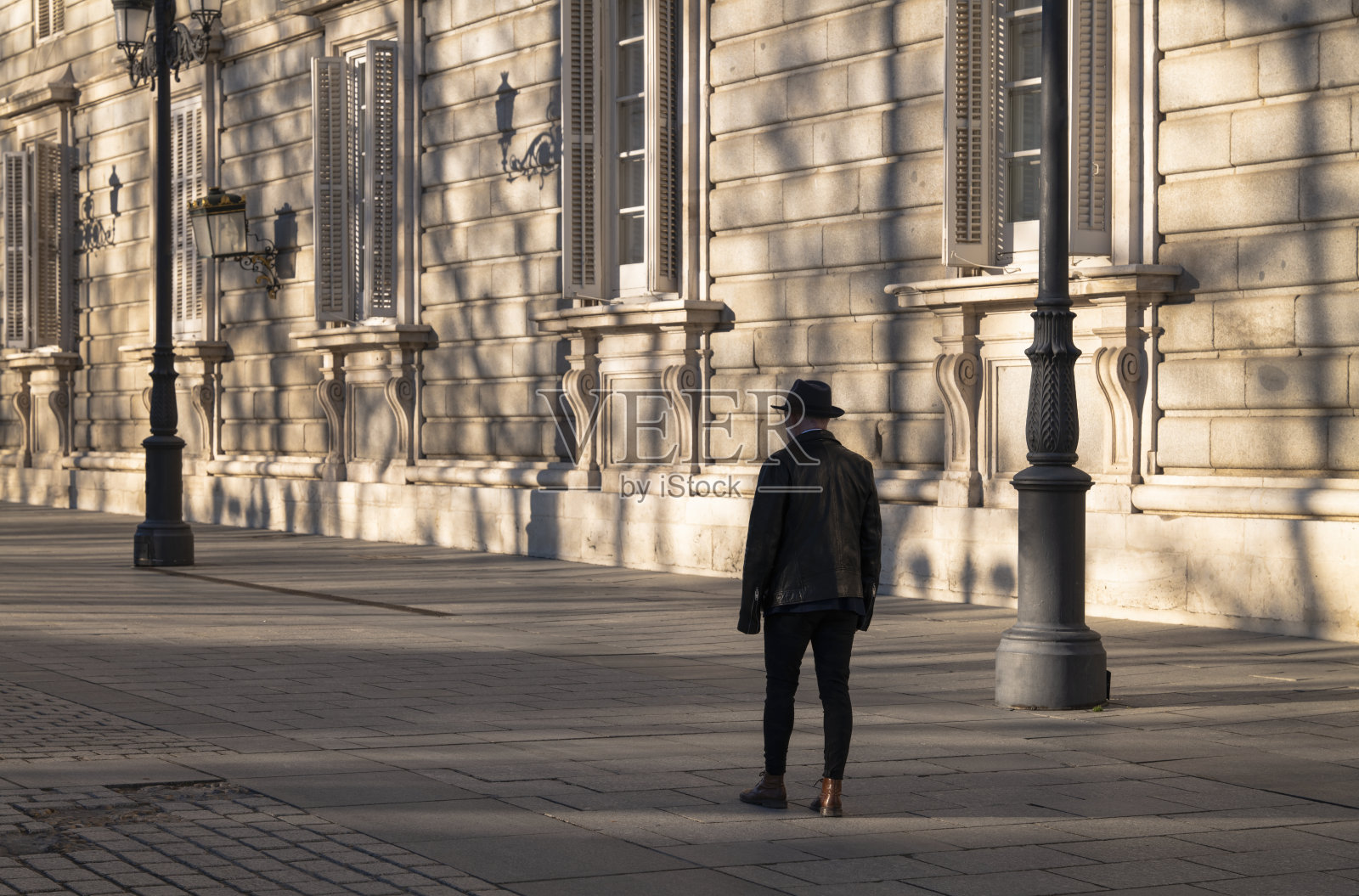 后视图的成人男子在街上走在帽子和皮夹克。马德里,西班牙照片摄影图片