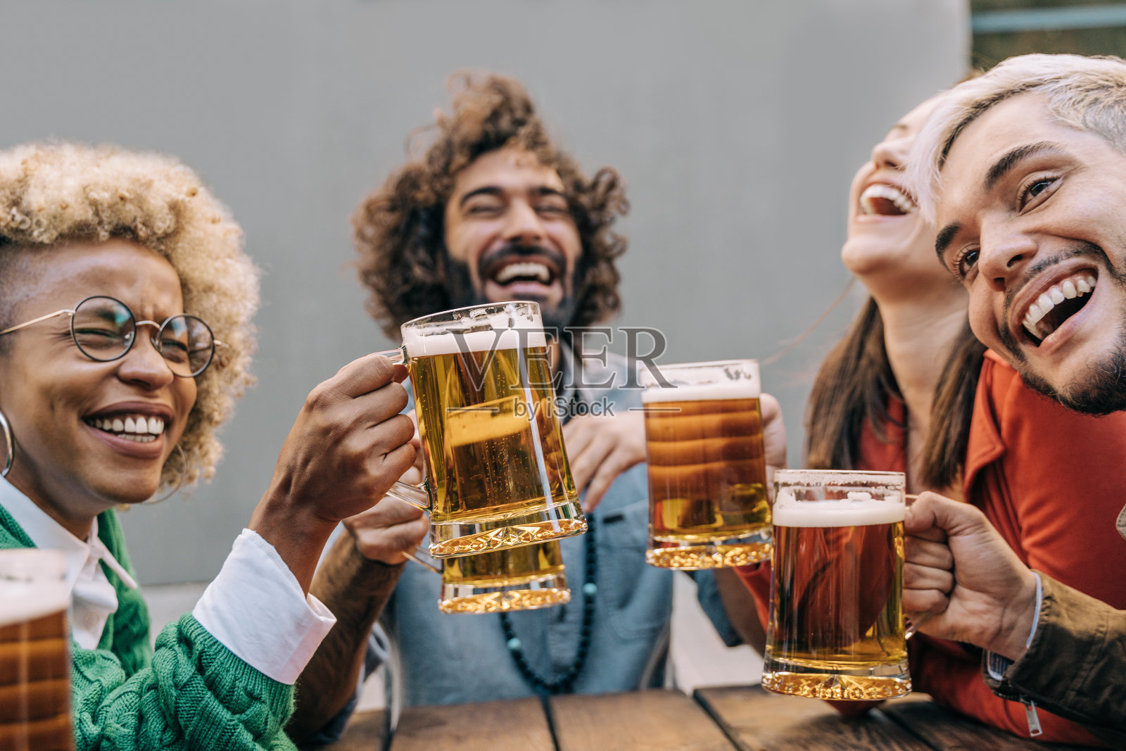 多种族朋友有乐趣,在啤酒厂酒吧餐厅户外啤酒欢呼-关注非洲女孩的手照片摄影图片