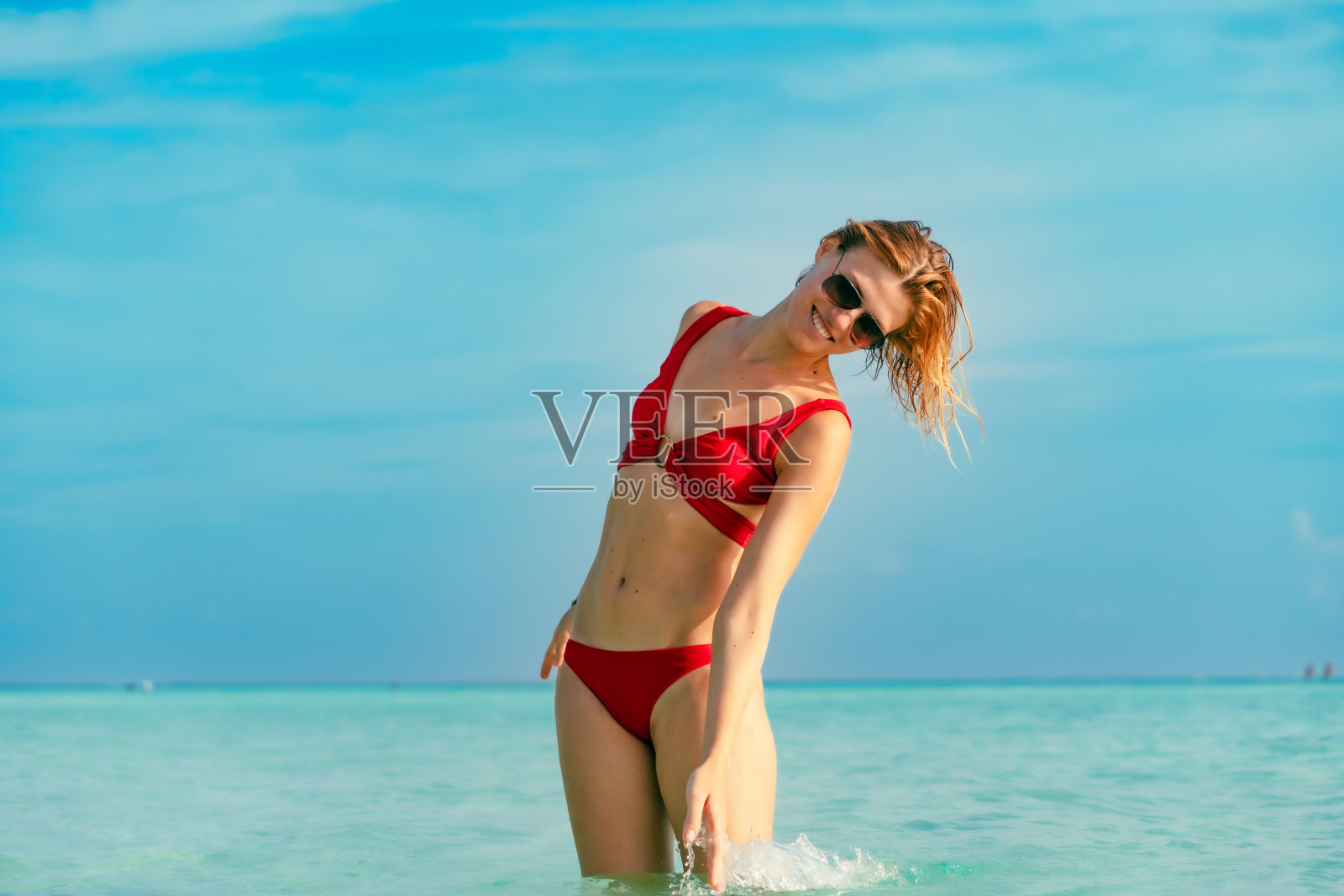 年轻女子在热带海水中触摸海水照片摄影图片