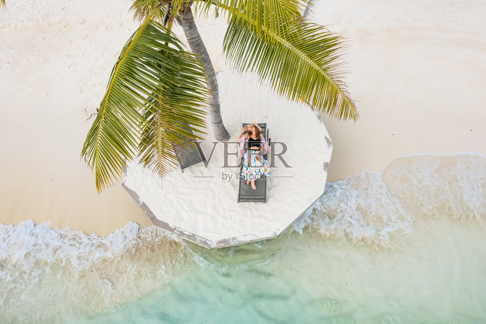 棕榈树下美丽女人的无人机视图照片摄影图片