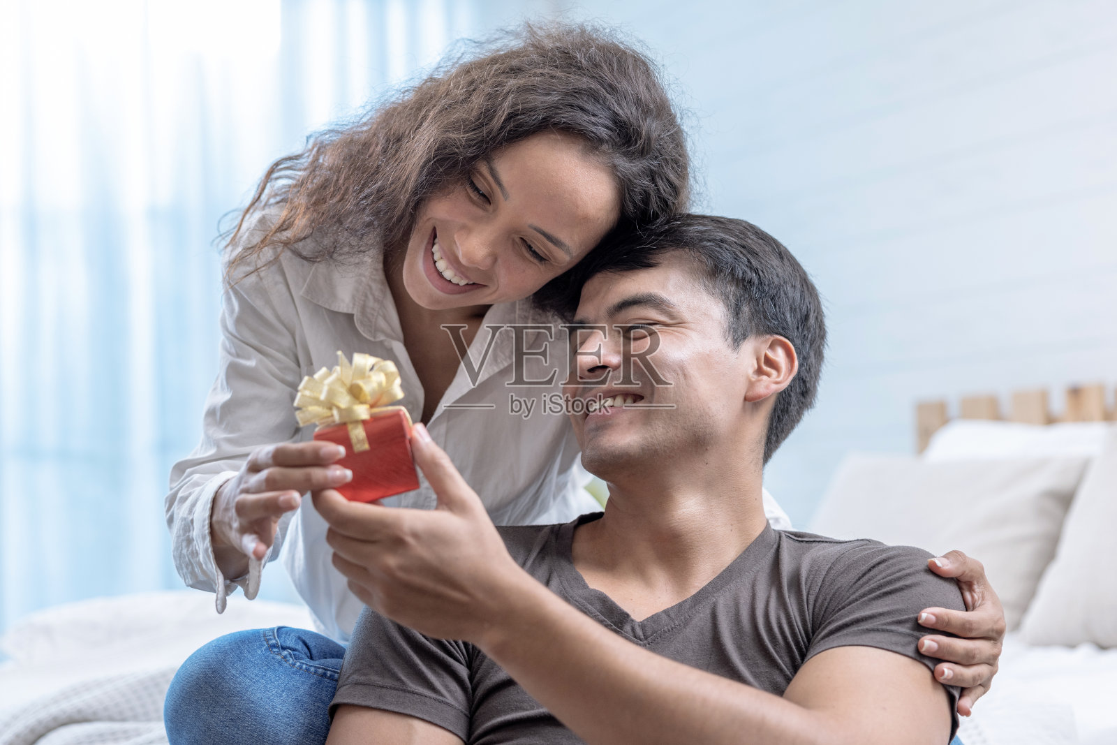 英俊的男朋友给他美丽的女朋友惊喜,给她一个礼物,快乐的夫妇,求婚,结婚纪念日,情人节。照片摄影图片