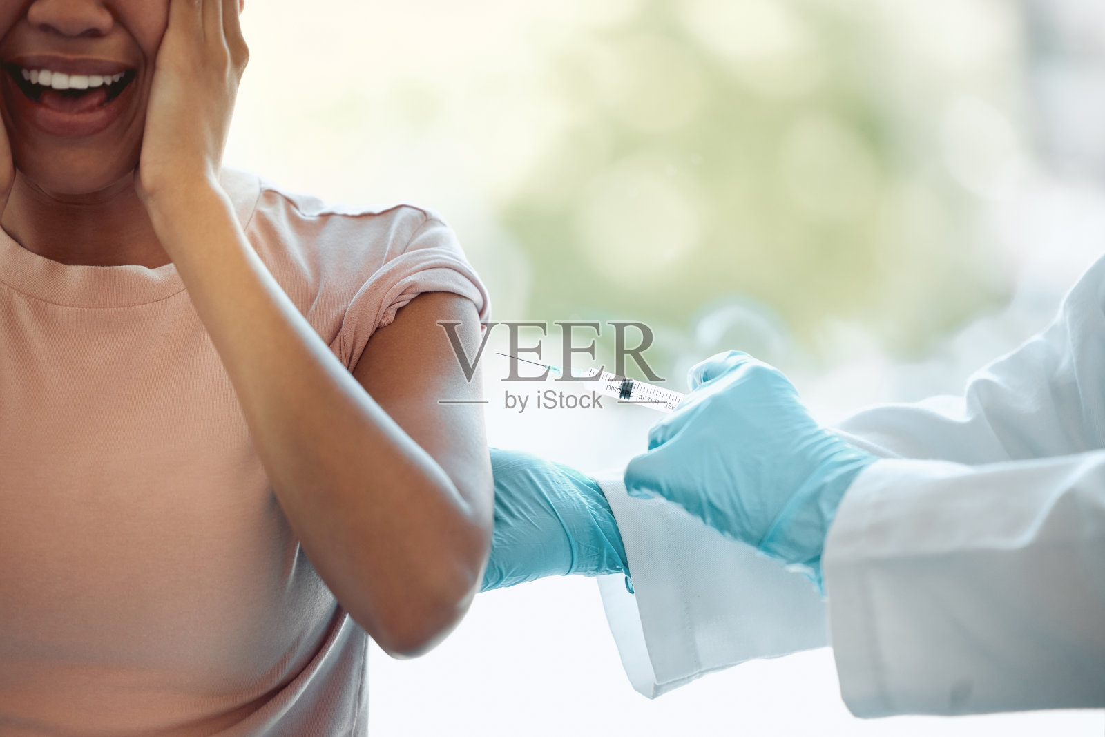 剪裁镜头的一个不认识的女人坐和感觉压力,而得到一针在诊所照片摄影图片