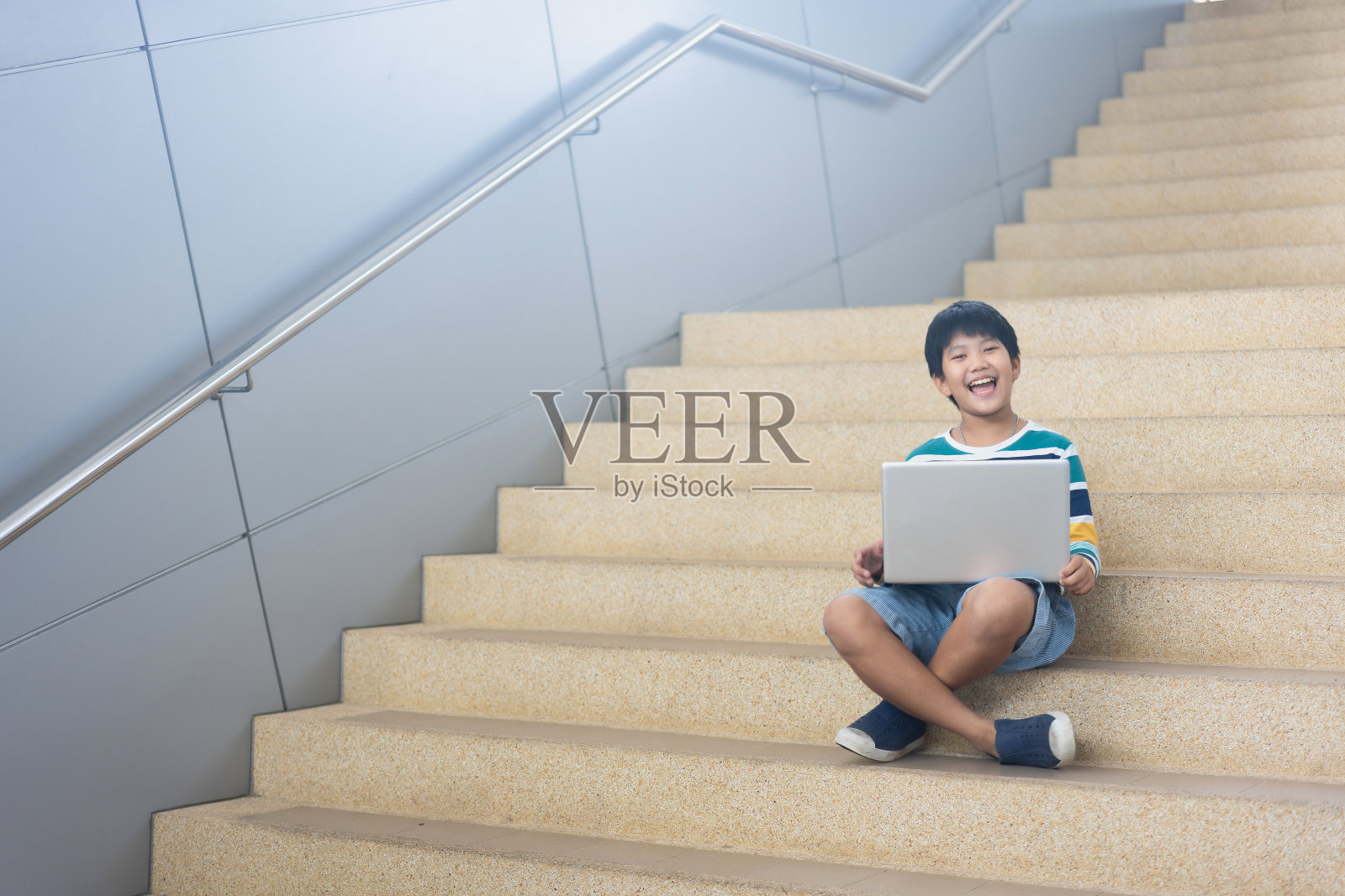 可爱的亚洲男孩学习或玩笔记本电脑游戏的肖像照片摄影图片