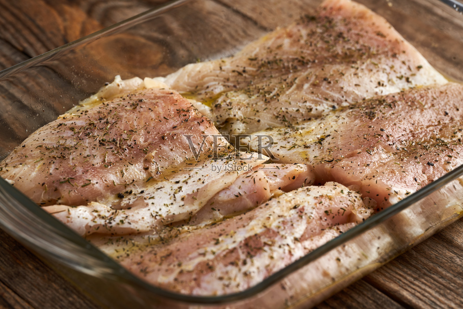 玻璃托盘里的调味过的梭鲈片照片摄影图片