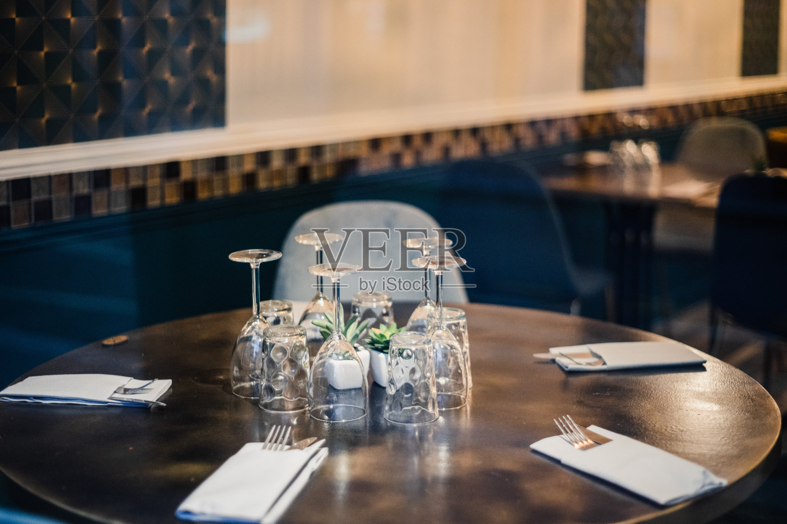 餐厅外的餐桌。选择性聚焦于背景模糊的桌子上的酒杯。照片摄影图片