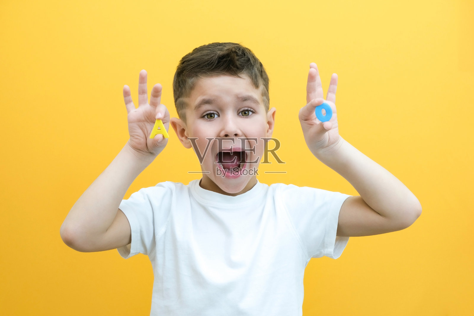 语言治疗。蹒跚学步的男孩说了这封信照片摄影图片