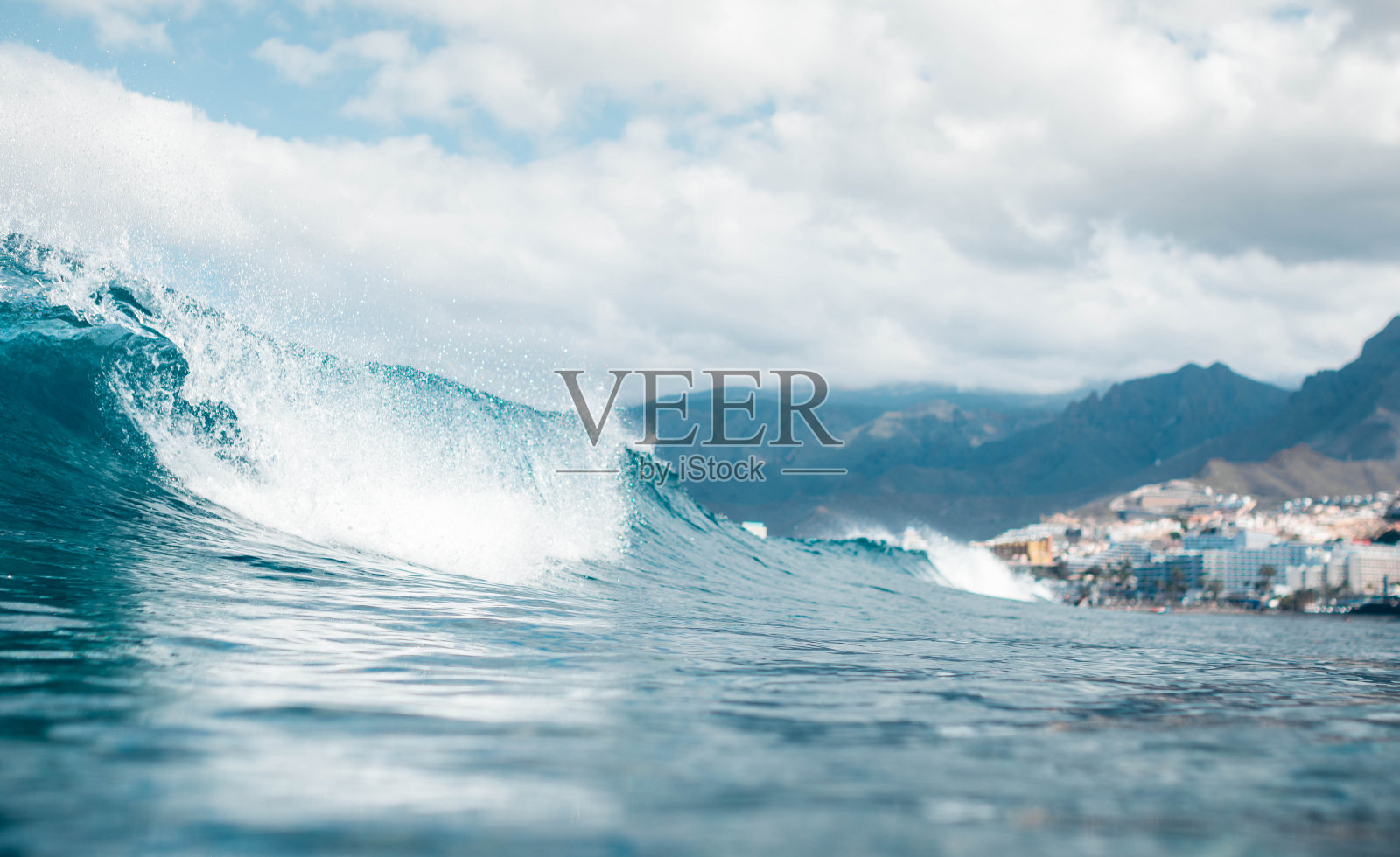 在阴天,以建筑物为背景的碎浪的低角度。美洲岛,特内里费岛照片摄影图片