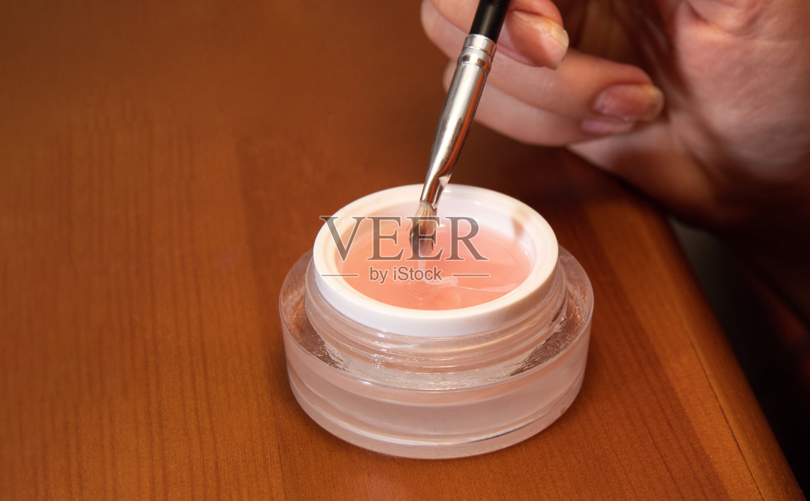 手握着刷子,触摸罐子里的凝胶。图片美容网站。有选择性的重点。照片摄影图片