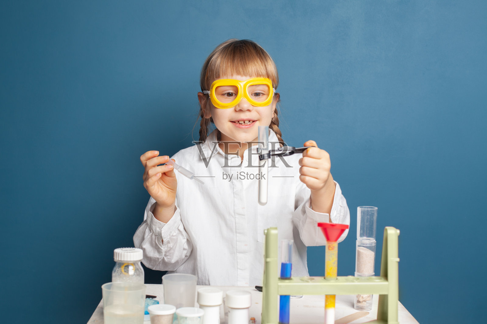 拿着化学瓶的快乐小女孩。科教观念照片摄影图片