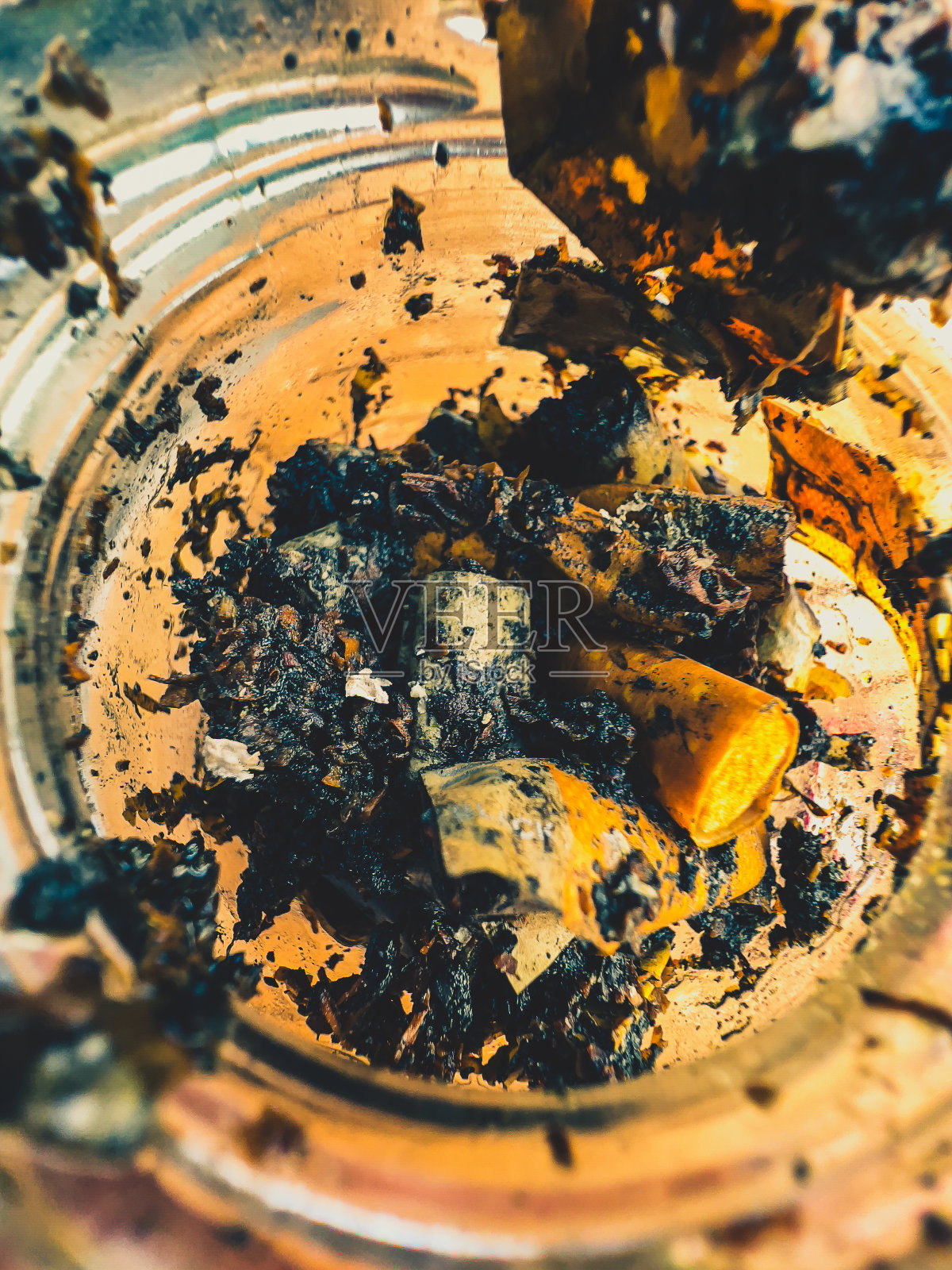 玻璃杯里的湿香烟。照片摄影图片