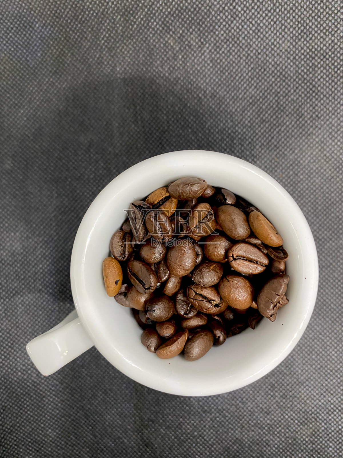 咖啡豆在一个咖啡杯特写俯视图与选择性焦点在前景照片摄影图片