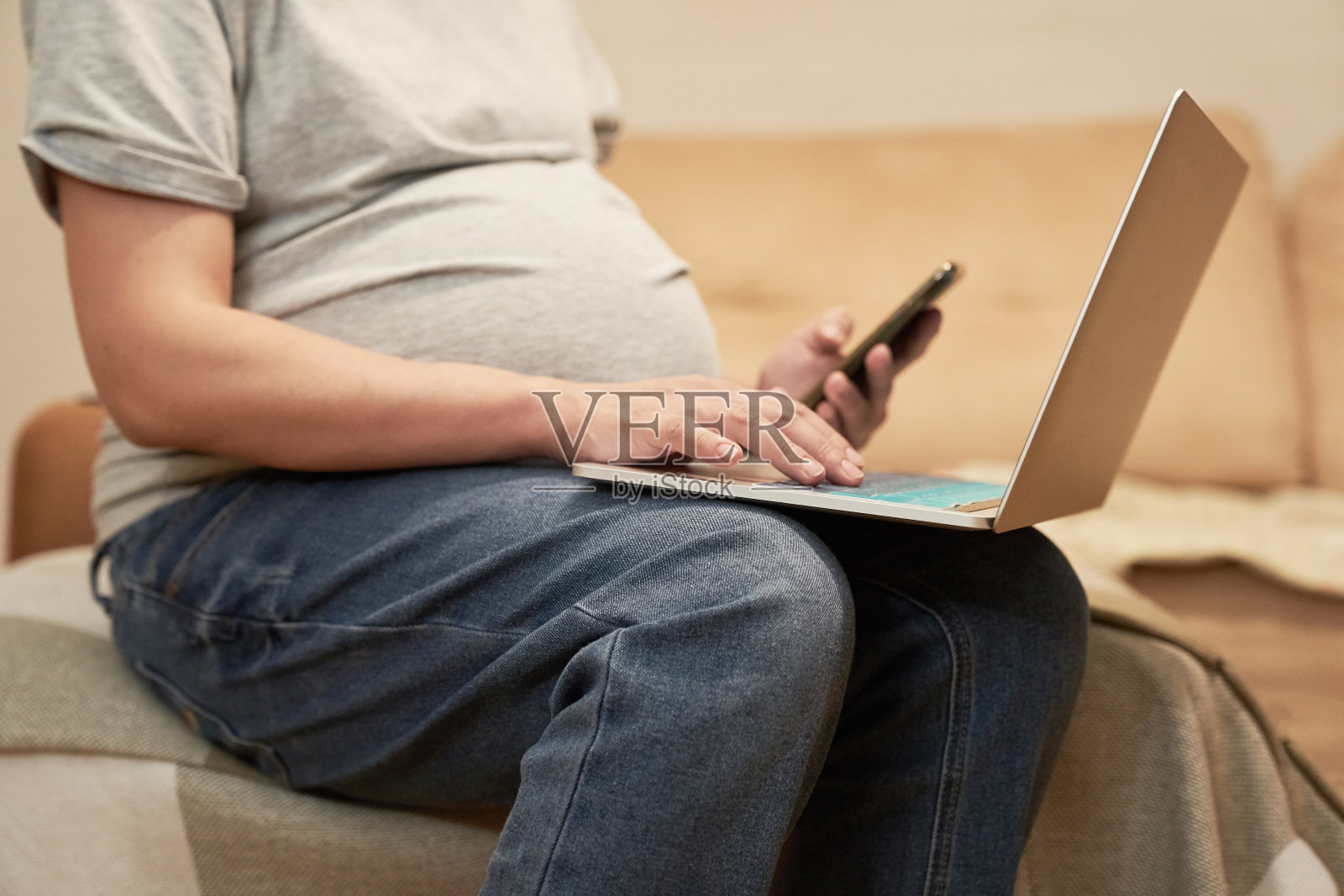 孕妇在家拿着手机就是坐在电脑前,网上购物照片摄影图片