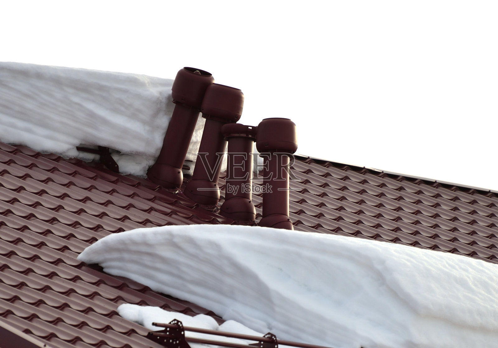 瓦屋顶上的管道被冰雪浸没而破裂照片摄影图片