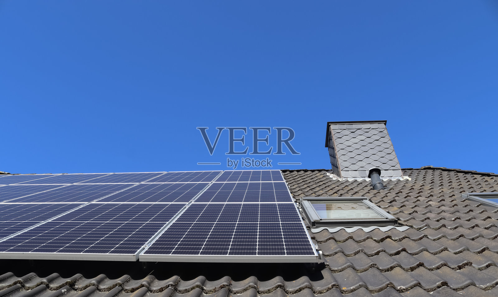 在住宅屋顶上产生清洁能源的太阳能电池板照片摄影图片