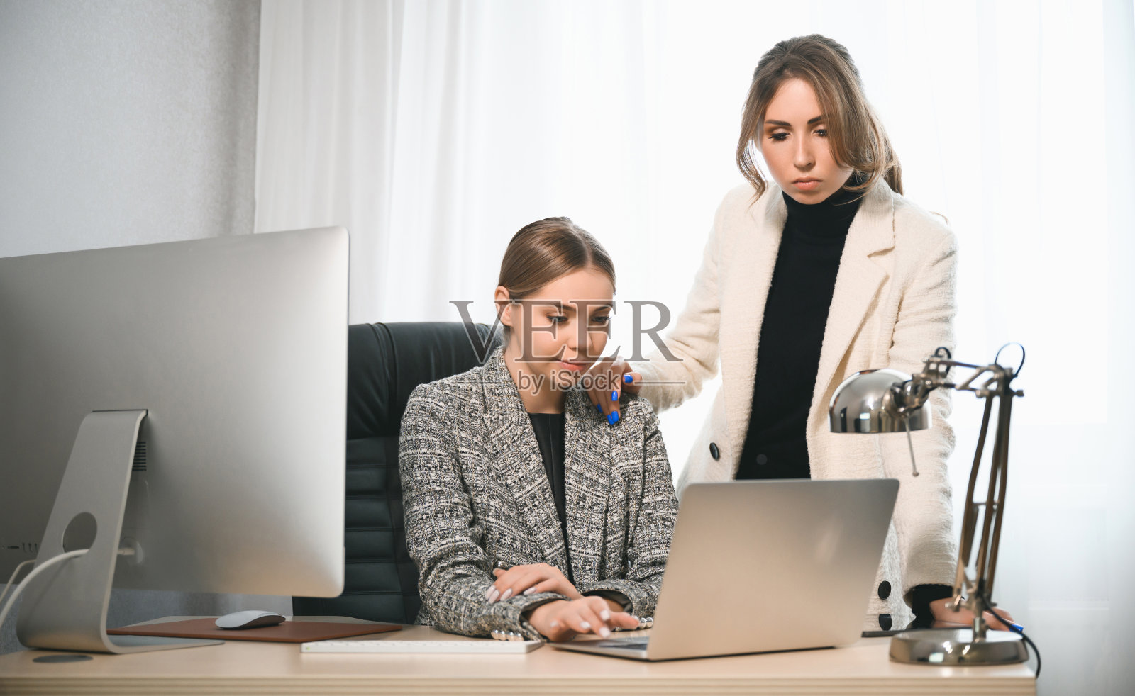 有魅力的年轻女性一起在办公室开会。一名新员工向导师咨询并提出一个新项目。开放空间的团队合作概念照片摄影图片