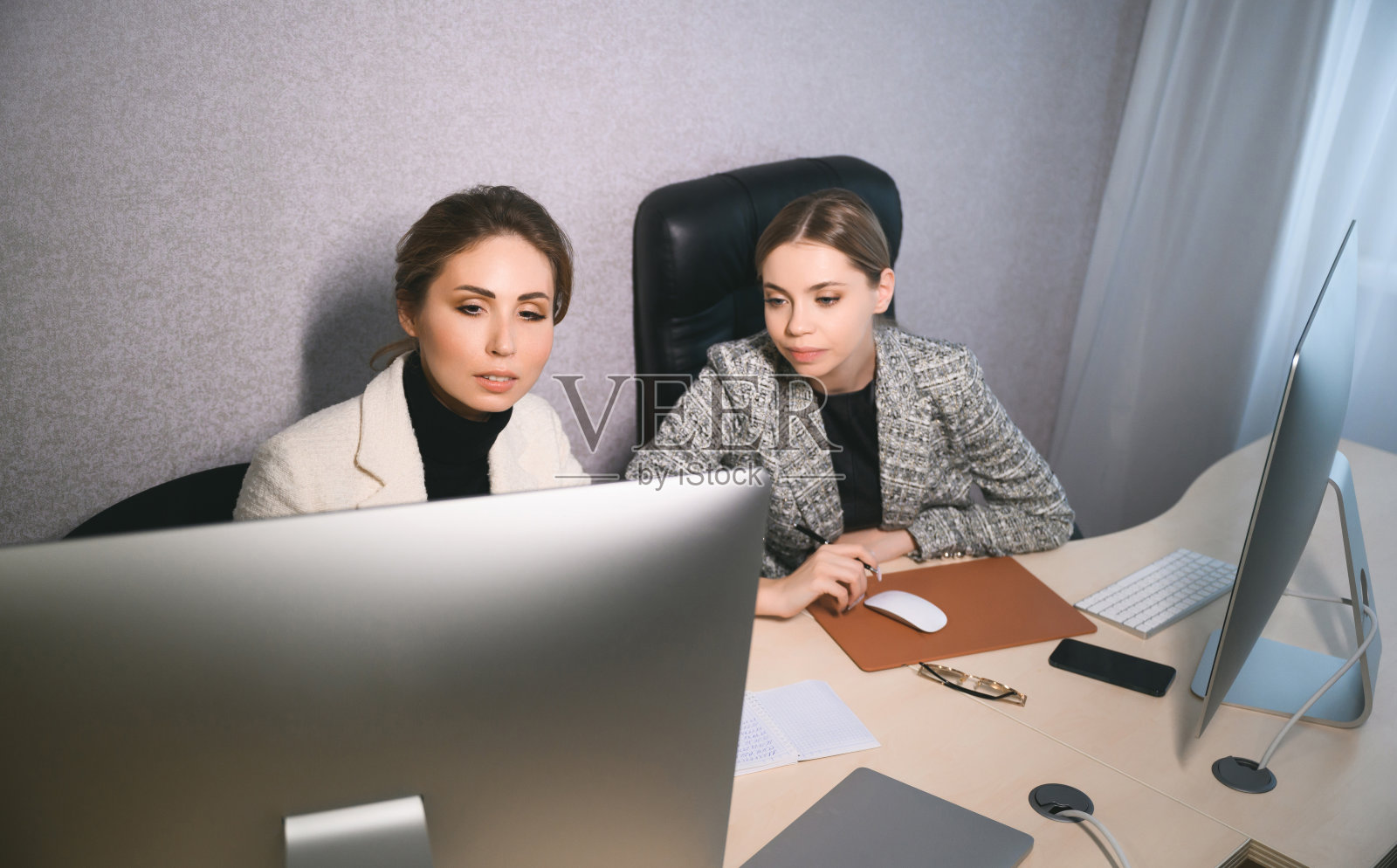 有魅力的年轻女性一起在办公室开会。一名新员工向导师咨询并提出一个新项目。开放空间的团队合作概念照片摄影图片