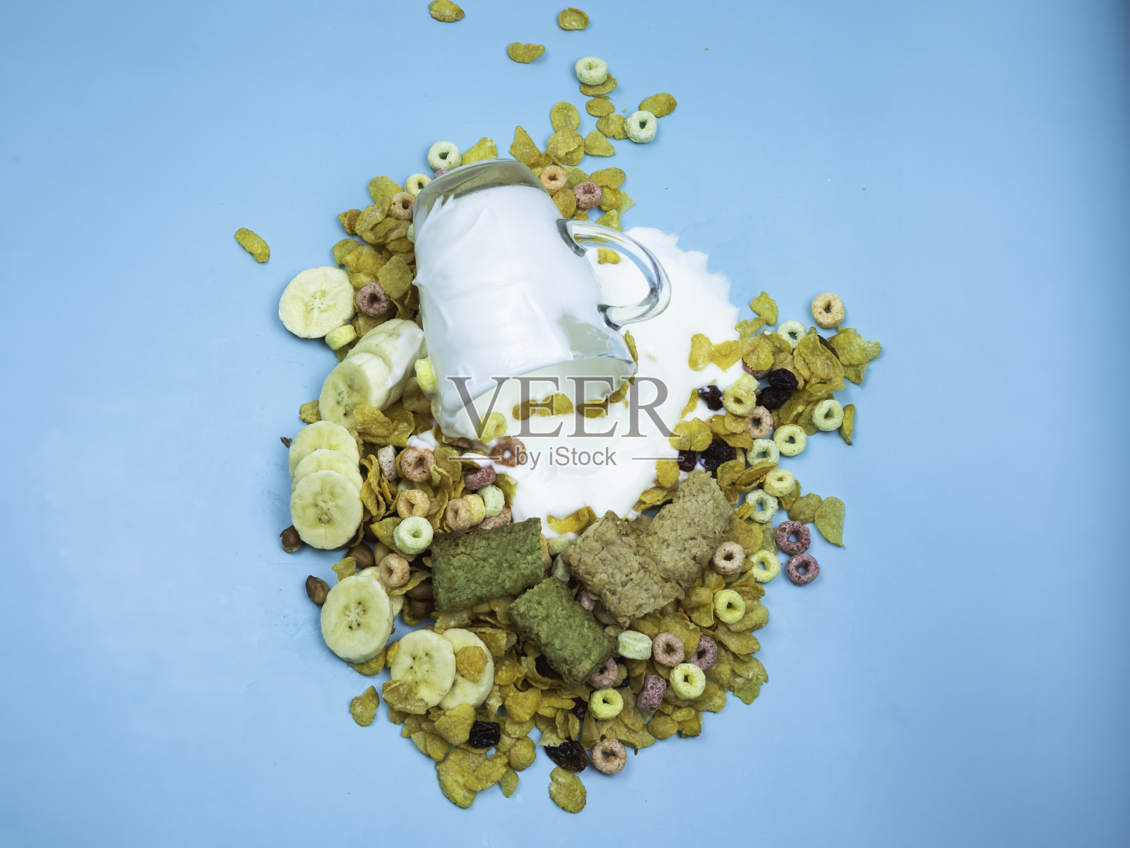 一杯酸奶浇在玉米片、香蕉片和谷物条上,照片摄影图片