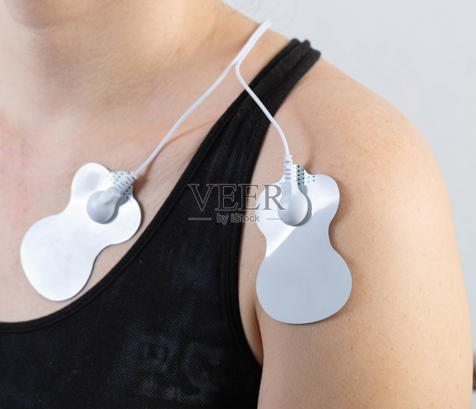 医用电针按摩器上的一个女孩。燃烧脂肪,促进健康。物理疗法,特写照片摄影图片