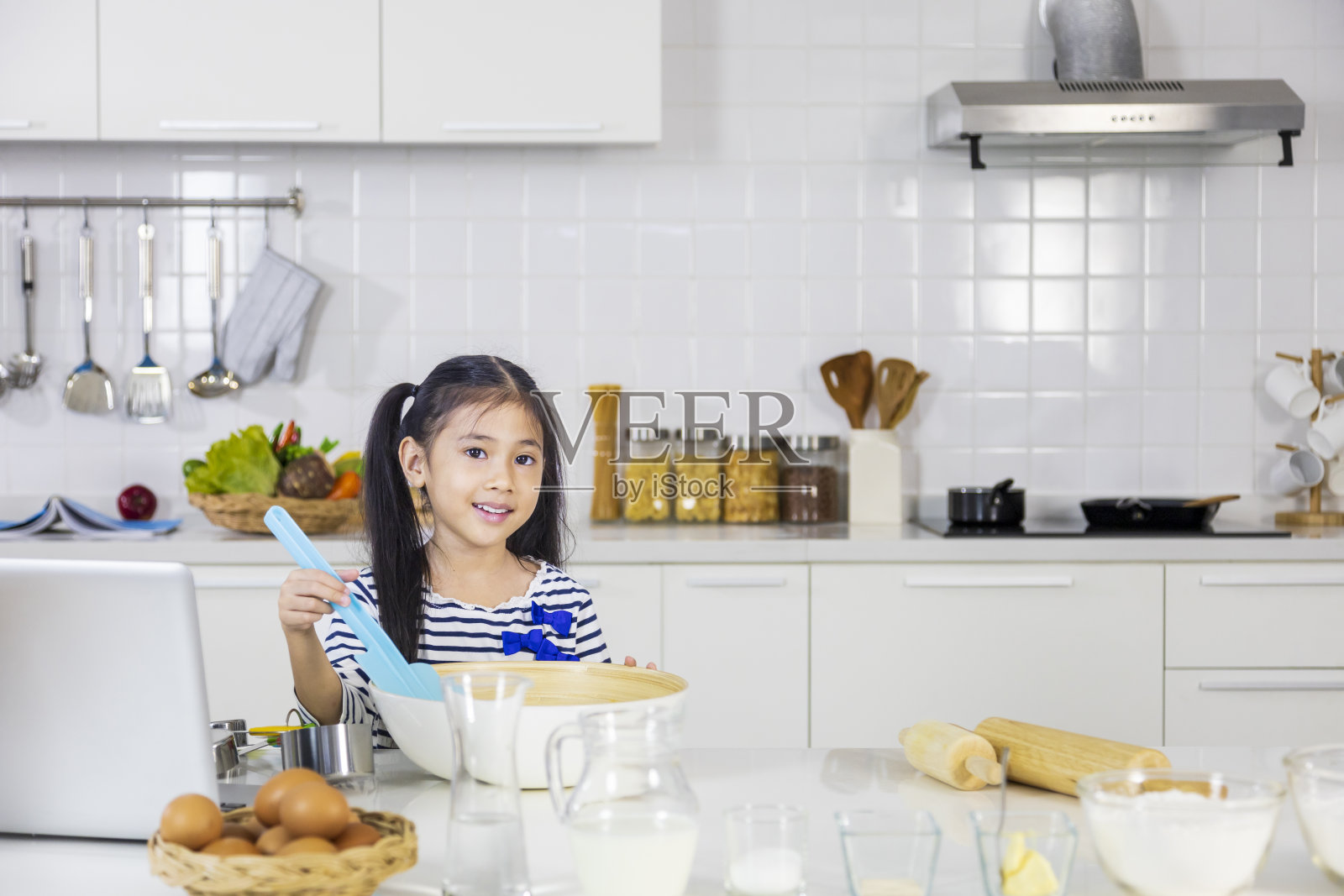 年轻的亚洲小女孩在现代化的厨房里准备面团做糕点,以适应烹饪和烘焙的概念照片摄影图片