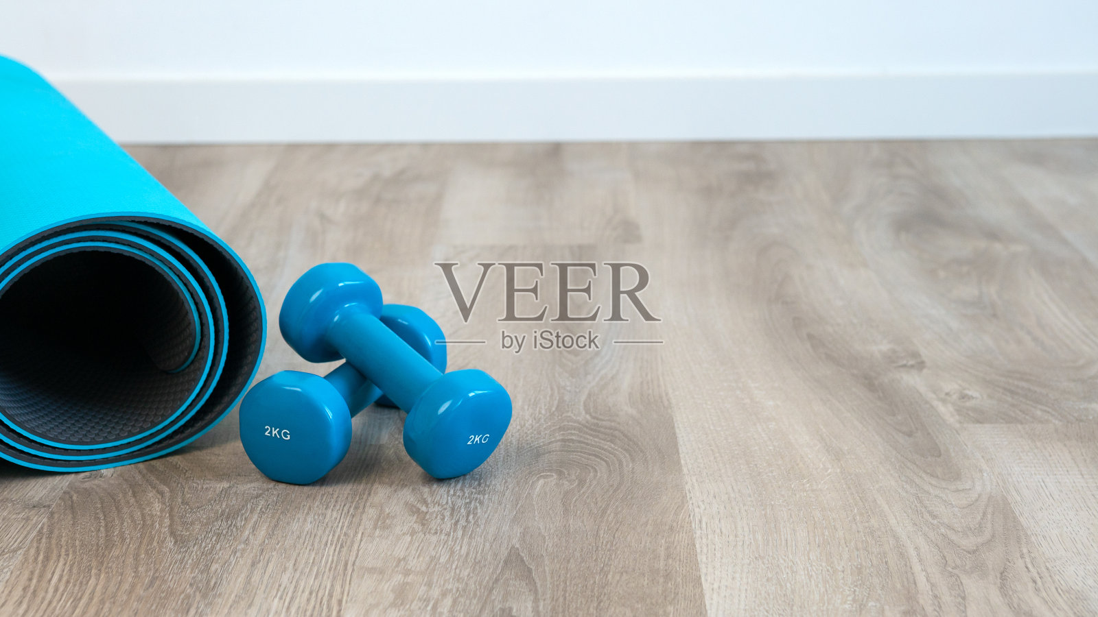 一对蓝色哑铃在室内地板上做健康瑜伽照片摄影图片