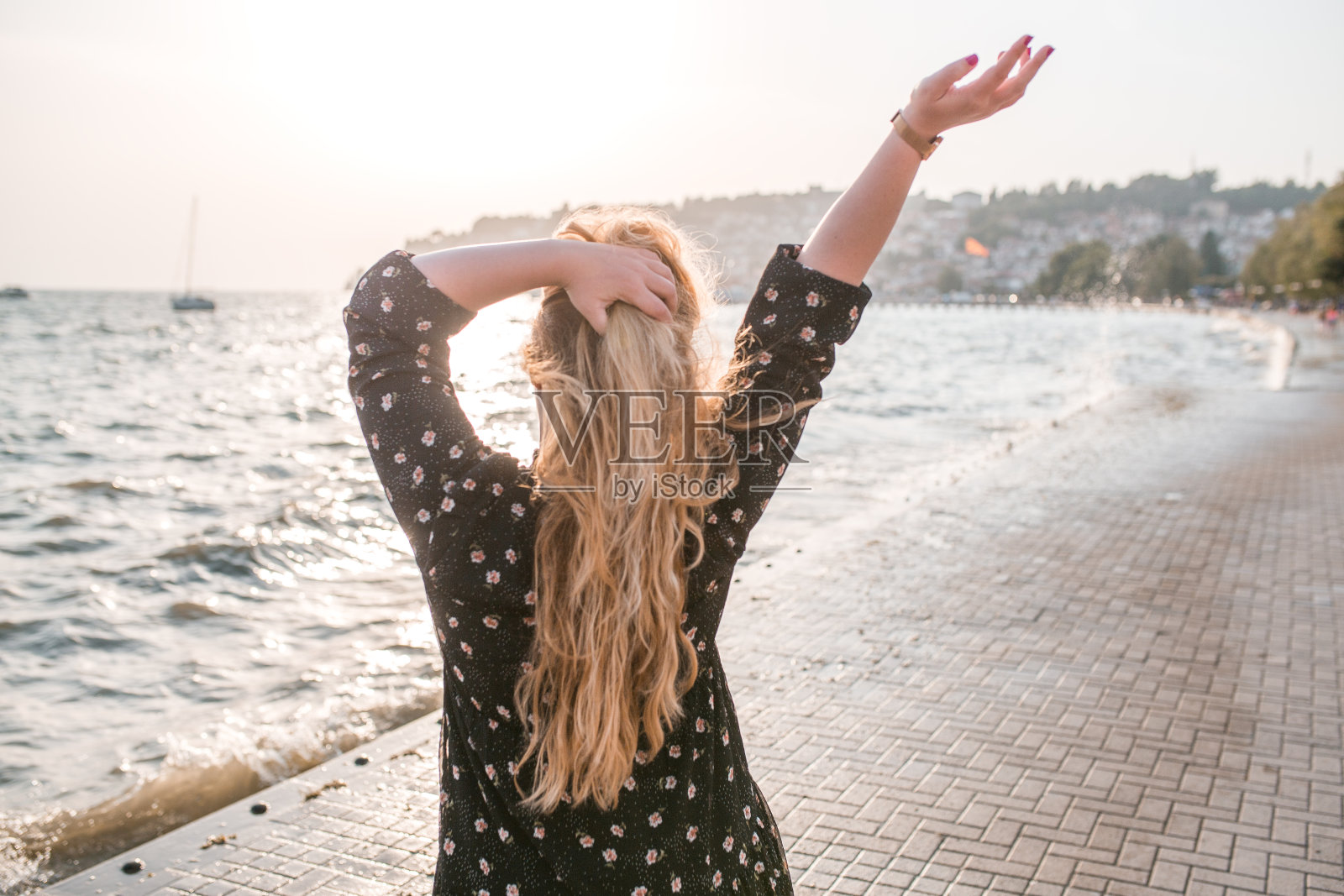 从一个女人的背后眺望大海的景色照片摄影图片