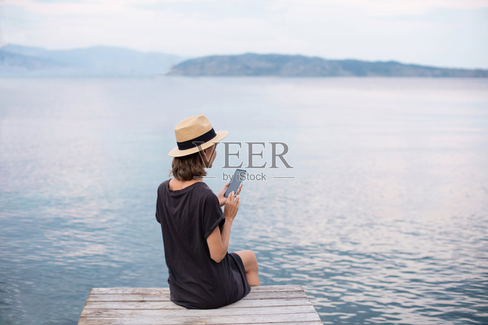 年轻女子在旅行中使用智能手机照片摄影图片