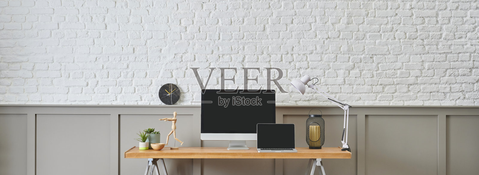 现代办公桌和木桌设计,电脑和笔记本风格,家居配件,灯和椅子装饰。白砖和棕色经典的墙背景。照片摄影图片