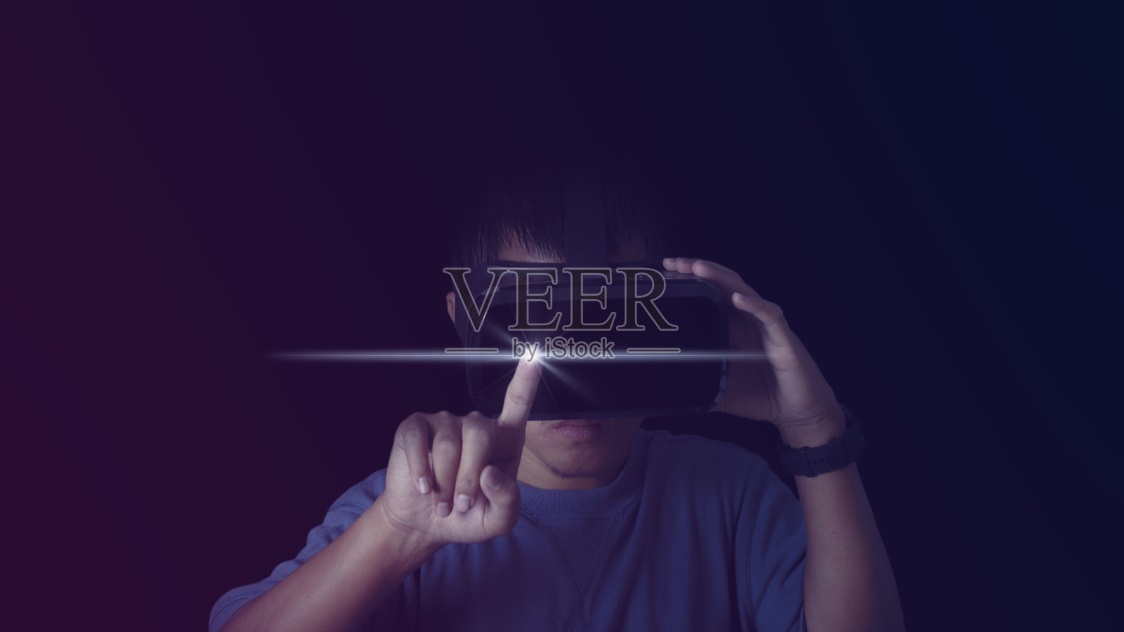 戴着VR头盔的男子用手指触摸霓虹灯背景上的东西。虚拟现实的眼镜和探索元世界。技术、游戏、娱乐理念。照片摄影图片