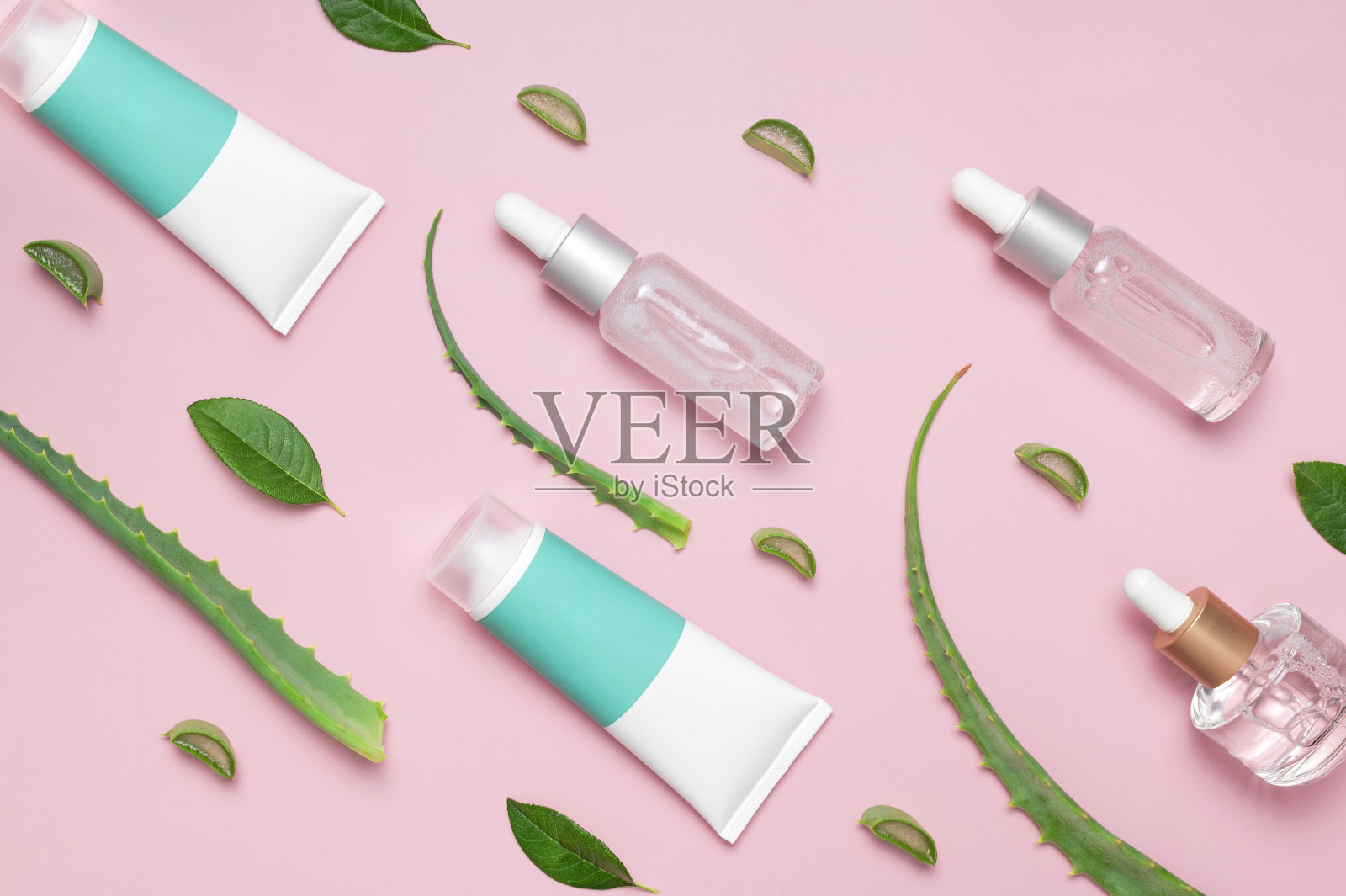 有机化妆品。天然化妆品的概念。化妆品油,血清,凝胶芦荟提取物在玻璃容器与移液管粉红色背景。俯视图平躺。化妆品SPA品牌模型照片摄影图片