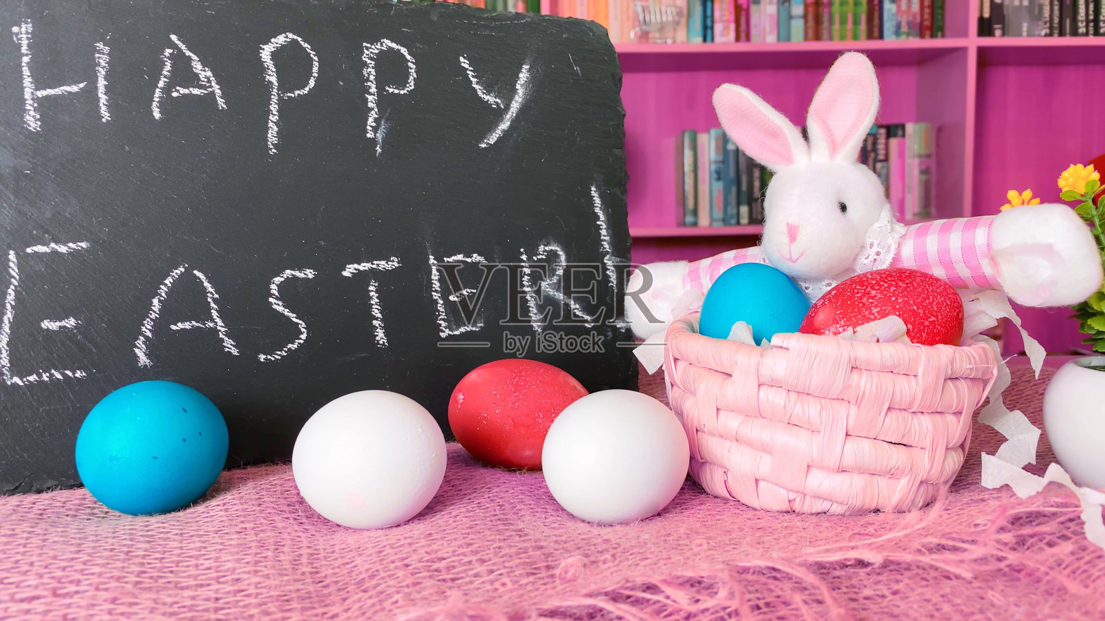 黑色学校董事会的复活节兔子带着彩色的蛋。刻字复活节快乐照片摄影图片