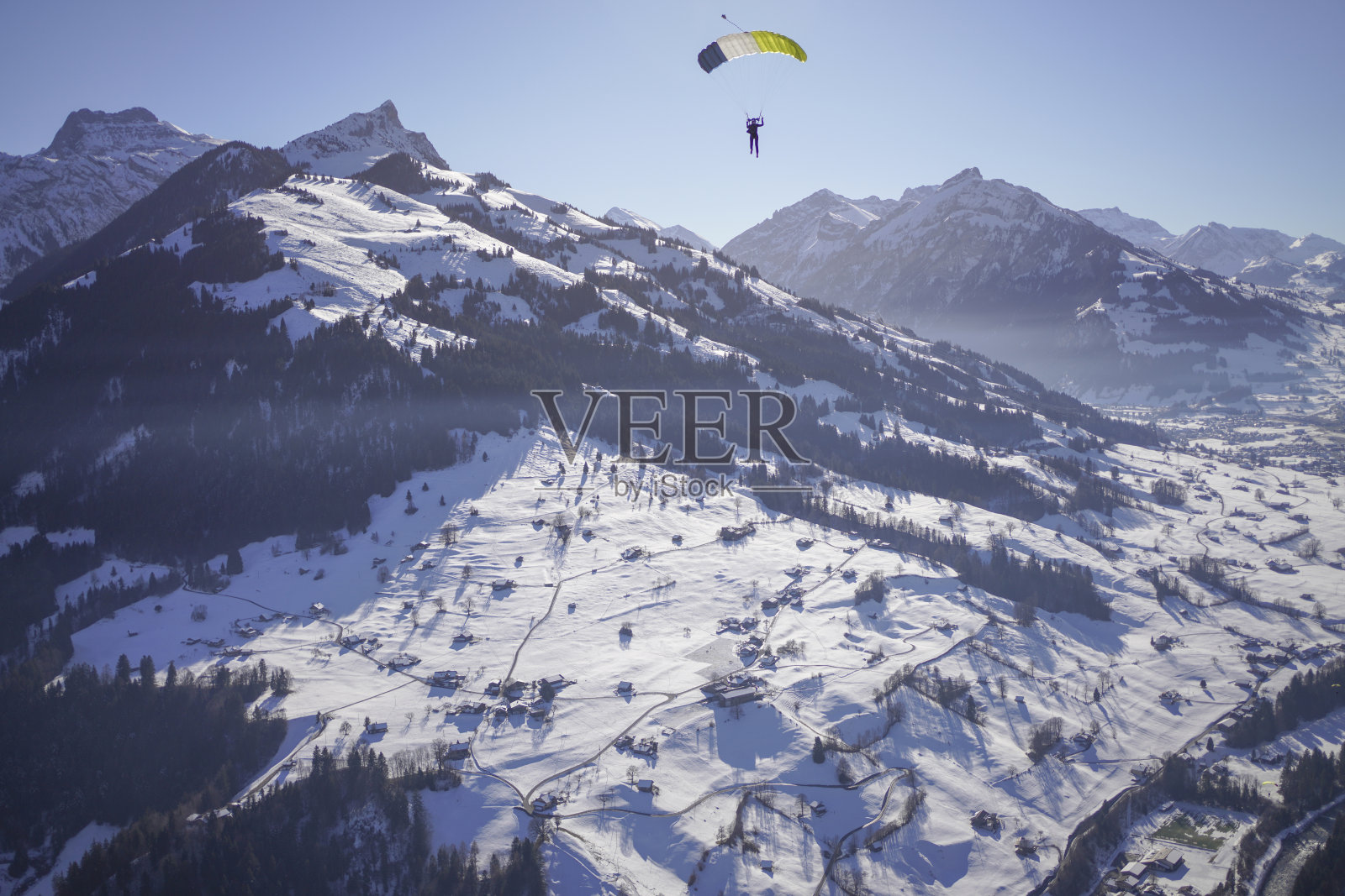 女性滑翔伞在晴朗的天空中滑翔照片摄影图片