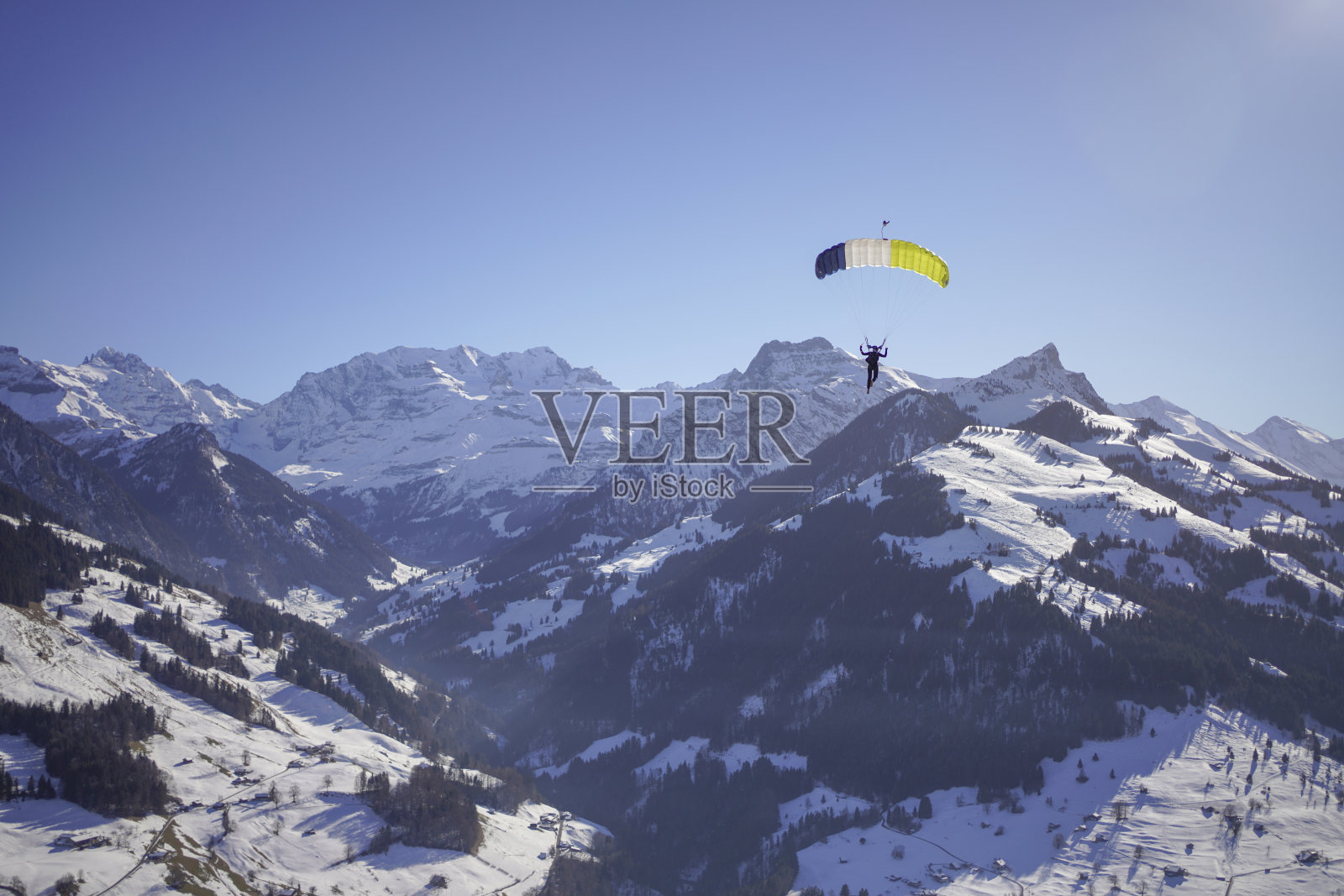 女性滑翔伞在晴朗的天空中滑翔照片摄影图片