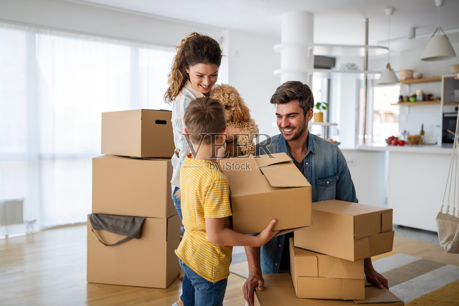 幸福的家庭,孩子们搬着箱子搬进了新公寓。照片摄影图片