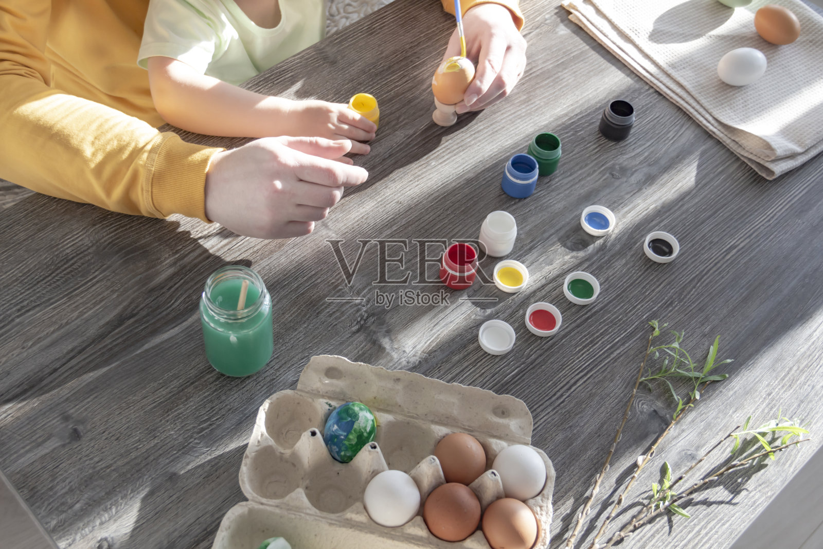 爸爸和孩子为复活节画彩蛋。照片摄影图片