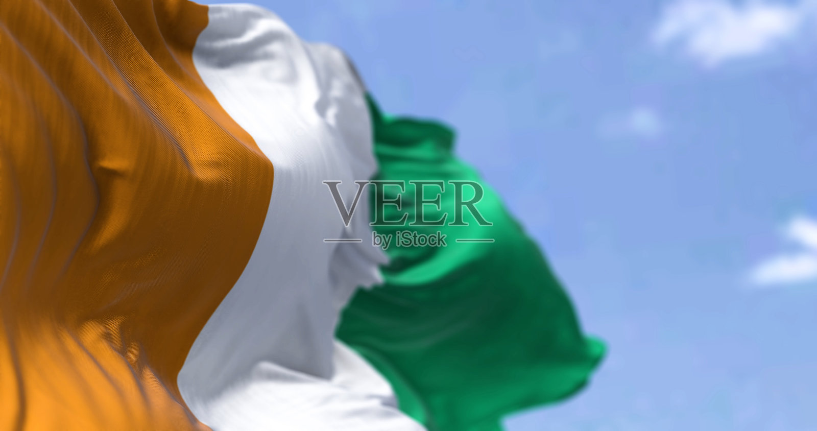 在一个晴朗的日子里,象牙海岸的国旗在风中飘扬照片摄影图片