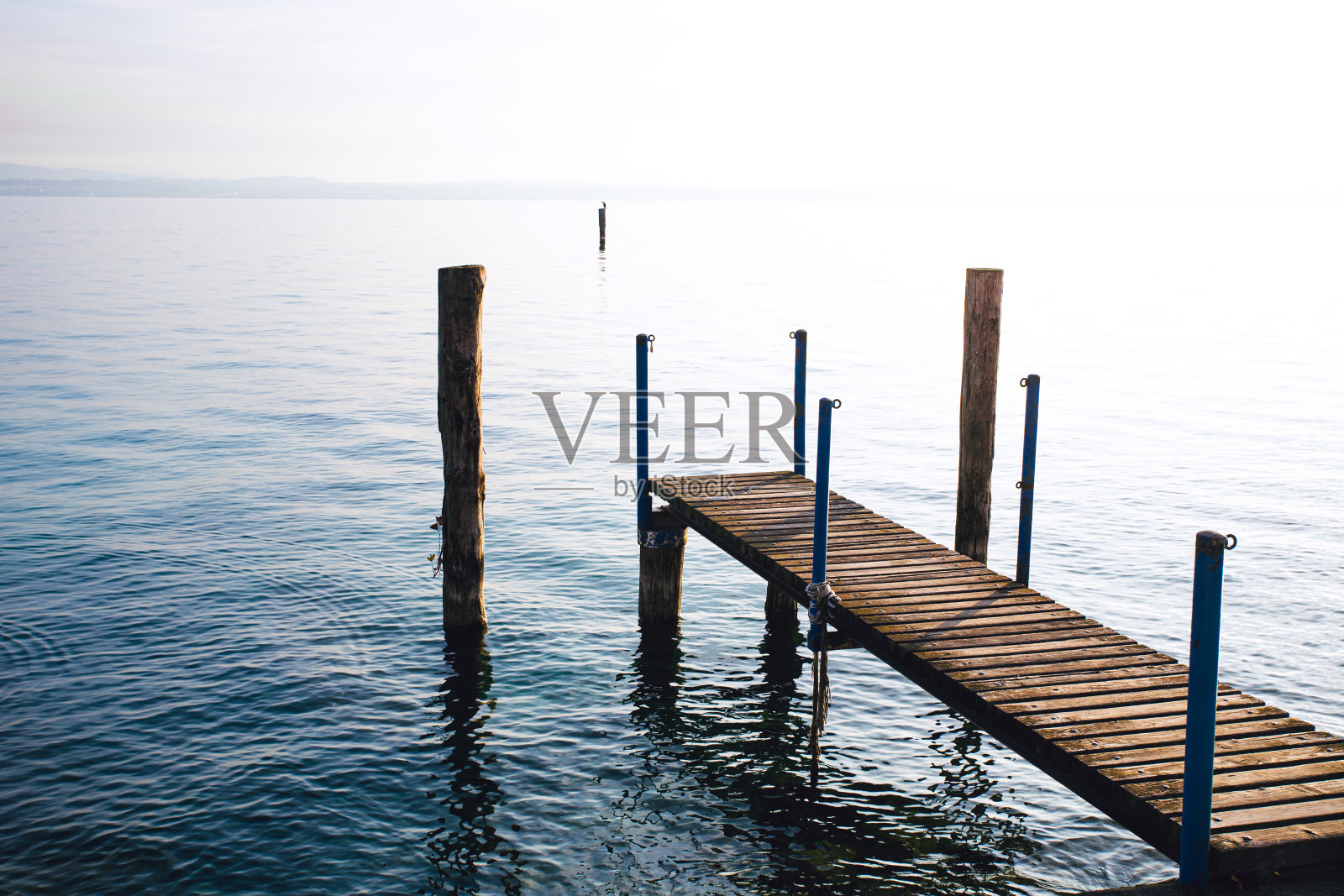 一个寒冷的冬日早晨,湖边的木制码头照片摄影图片