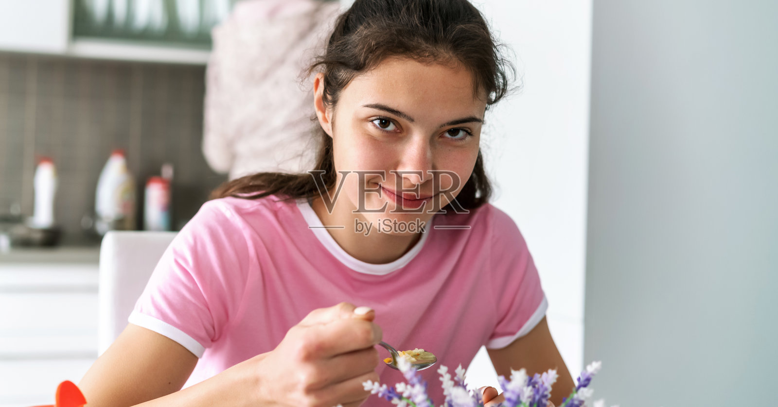 十几岁的女孩拿着盛汤的银匙微笑着照片摄影图片