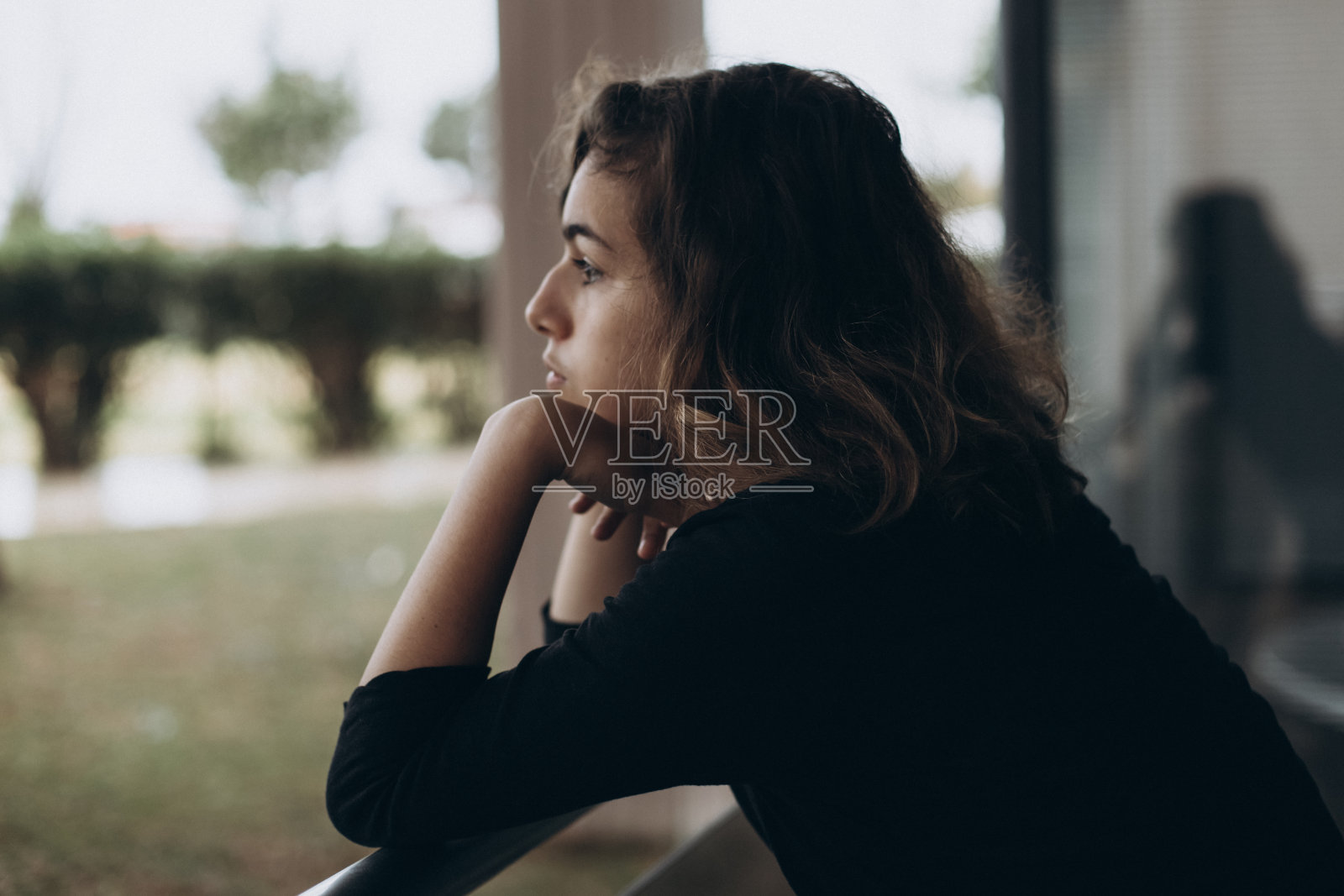 冷静漂亮的十几岁女孩在阳台上看向别处照片摄影图片