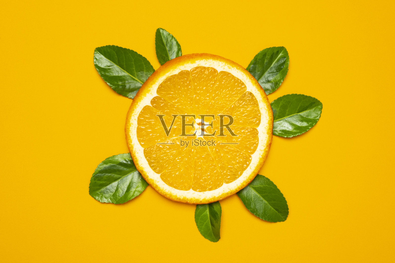 成熟多汁的桔子片,黄色背景上的绿叶。平躺顶视图。水果图案,创意明亮的夏季水果概念。柑橘类水果,维生素C照片摄影图片