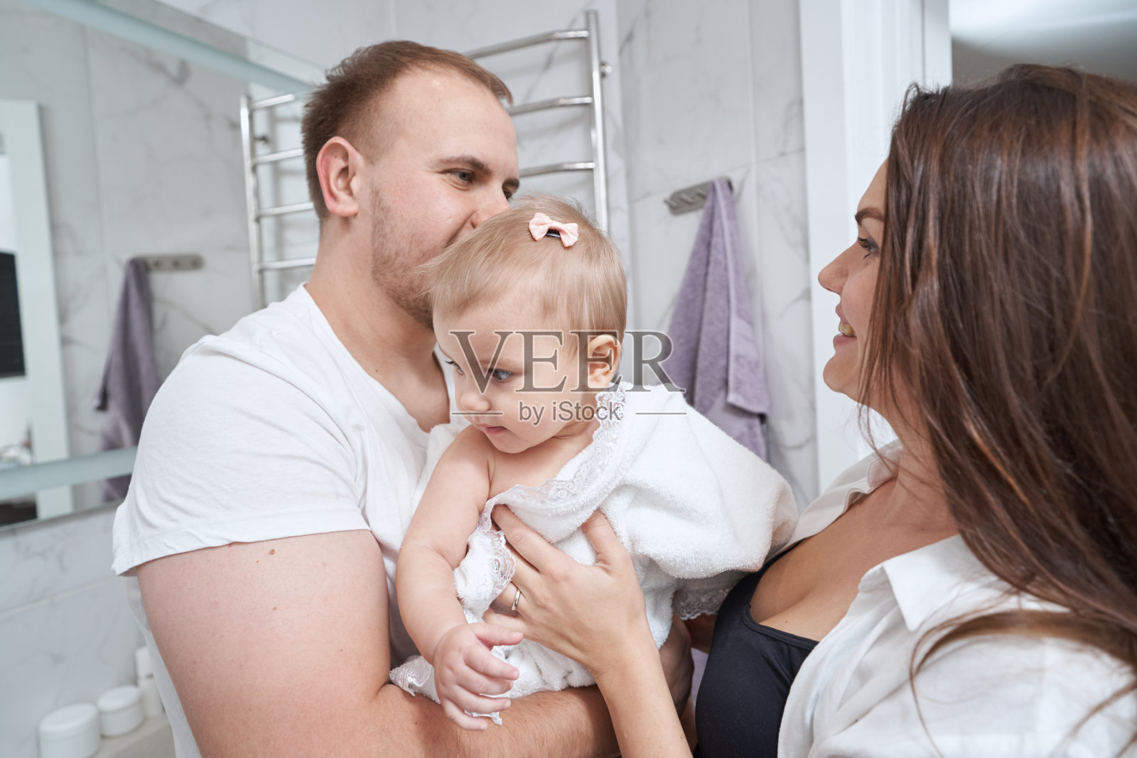 幸福的父母抱着孩子交换眼神照片摄影图片