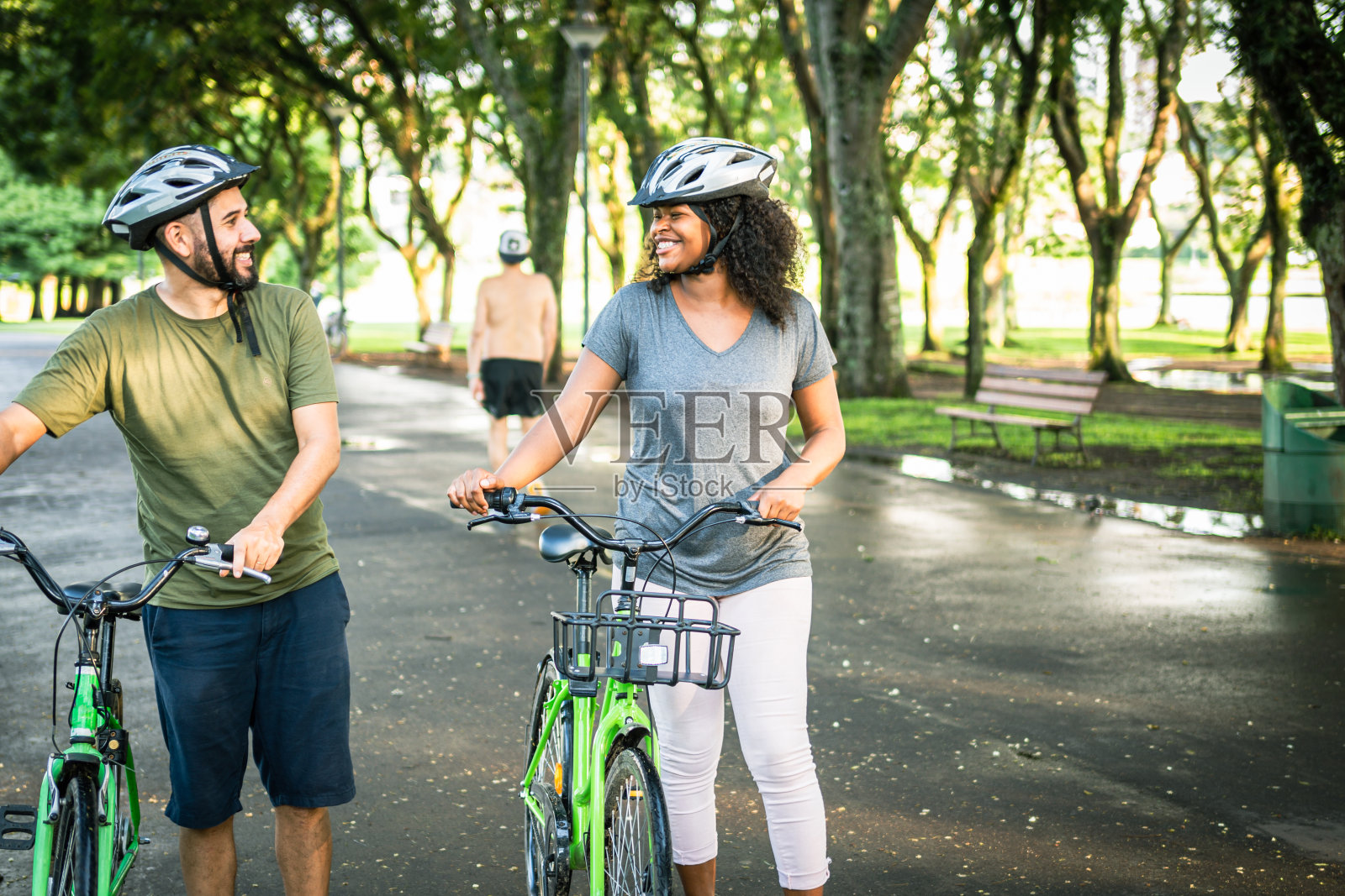 两个好朋友骑着自行车在公园里聊天照片摄影图片