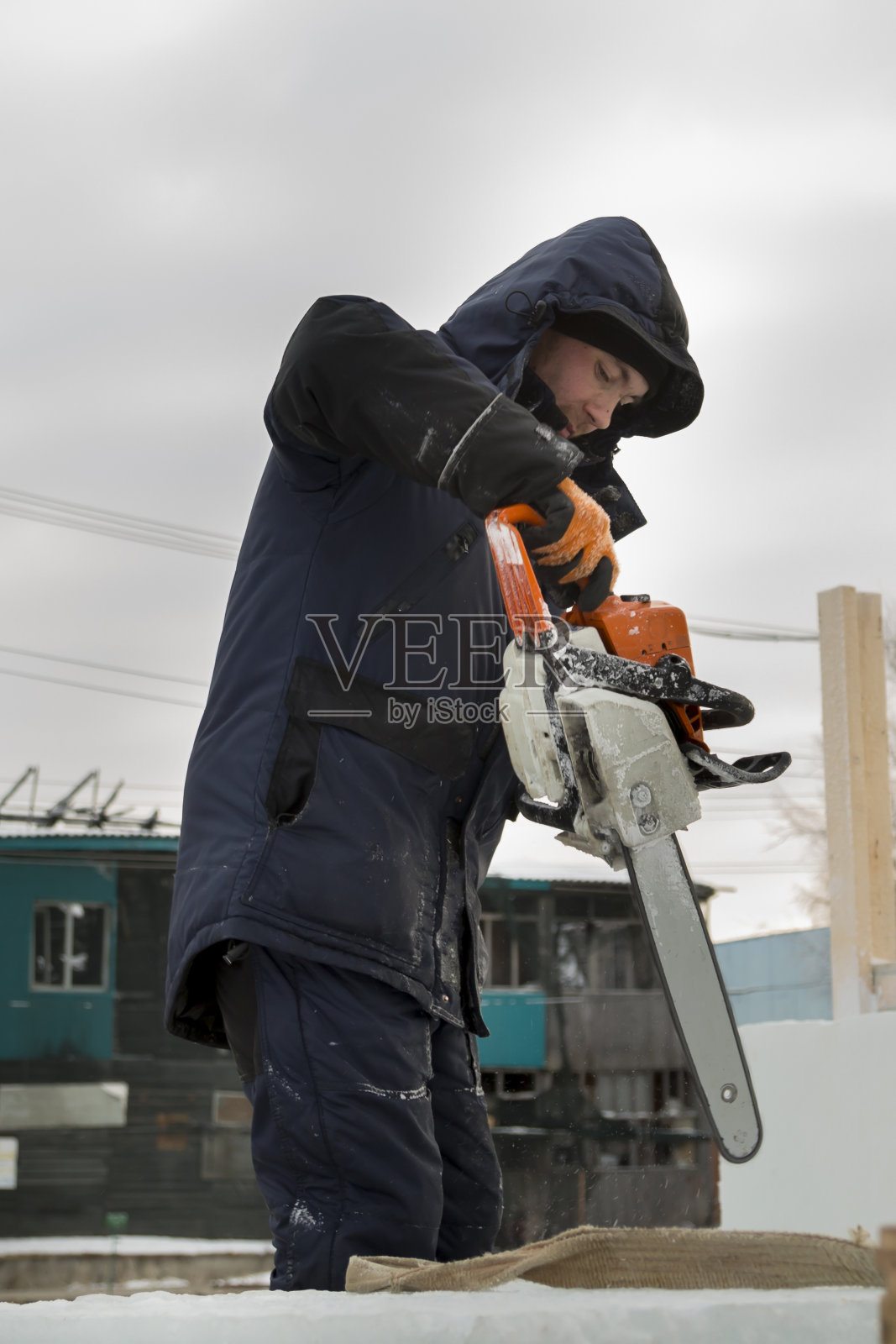 一个装配工人的肖像,他的手中拿着一个链锯照片摄影图片