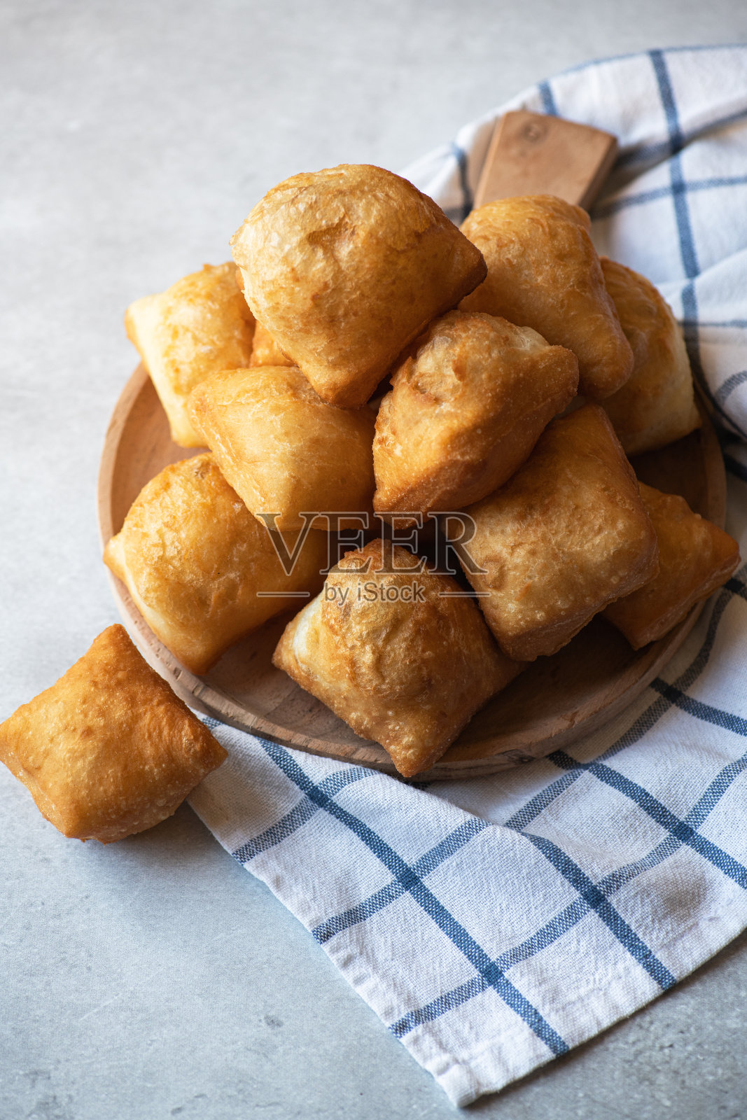 刚烤好的包萨克在灰色背景的木盘上。传统的哈萨克斯坦烘烤。照片摄影图片