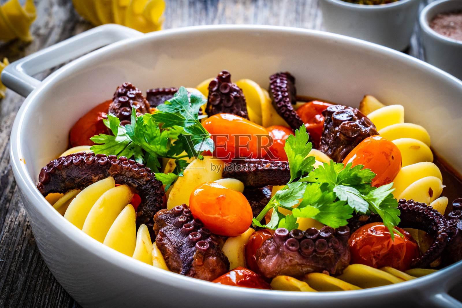 木桌上的烤章鱼和蔬菜通心粉照片摄影图片