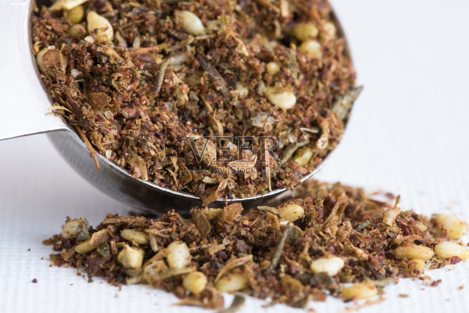 从茶匙中溢出的扎阿塔尔调味料照片摄影图片