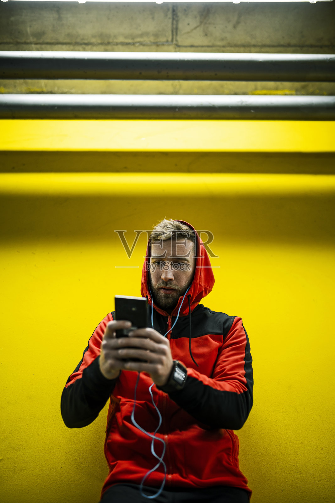 靠在黄色的墙上查看播放列表照片摄影图片