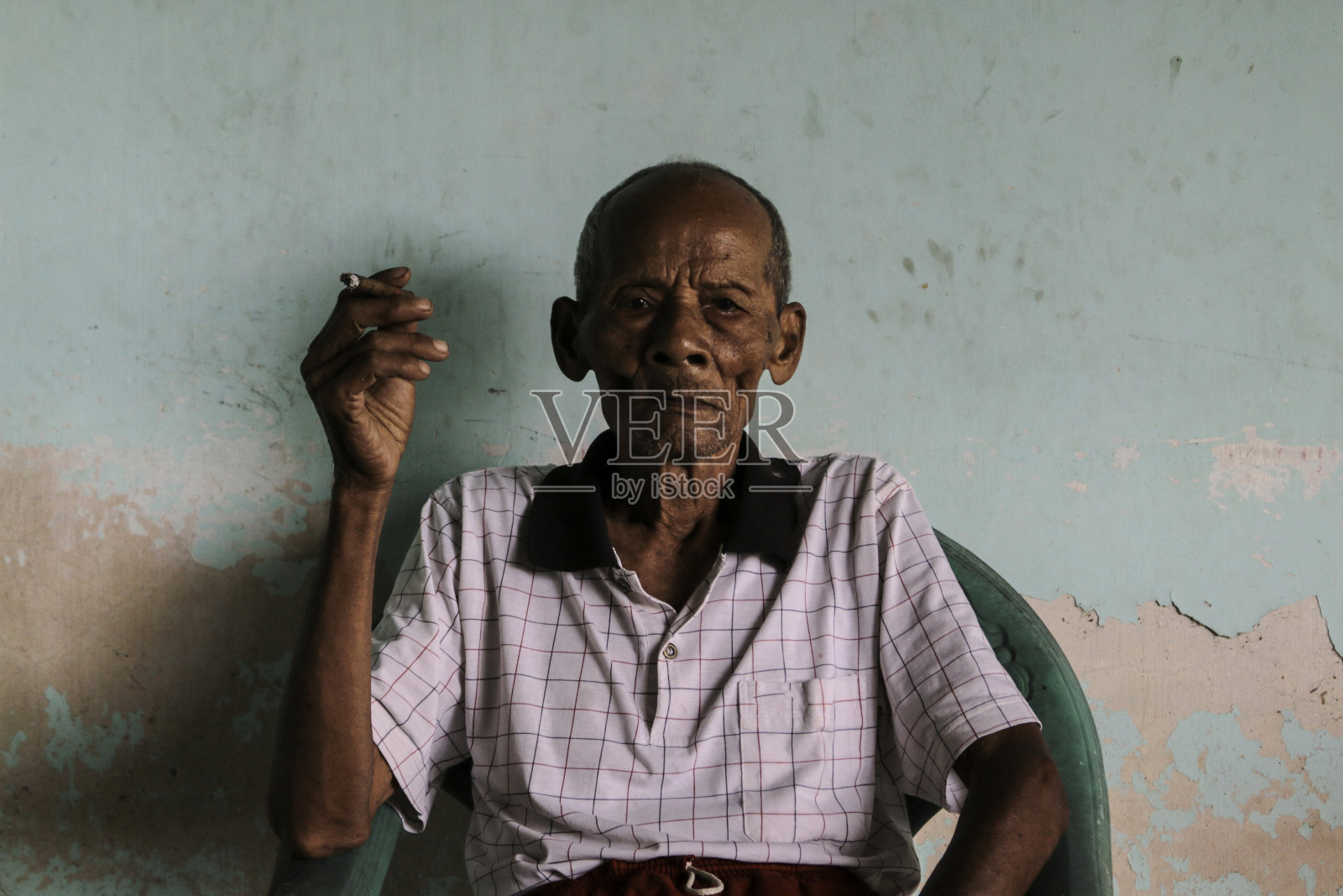 亚洲爪哇老人的特写肖像,手里拿着一支香烟照片摄影图片