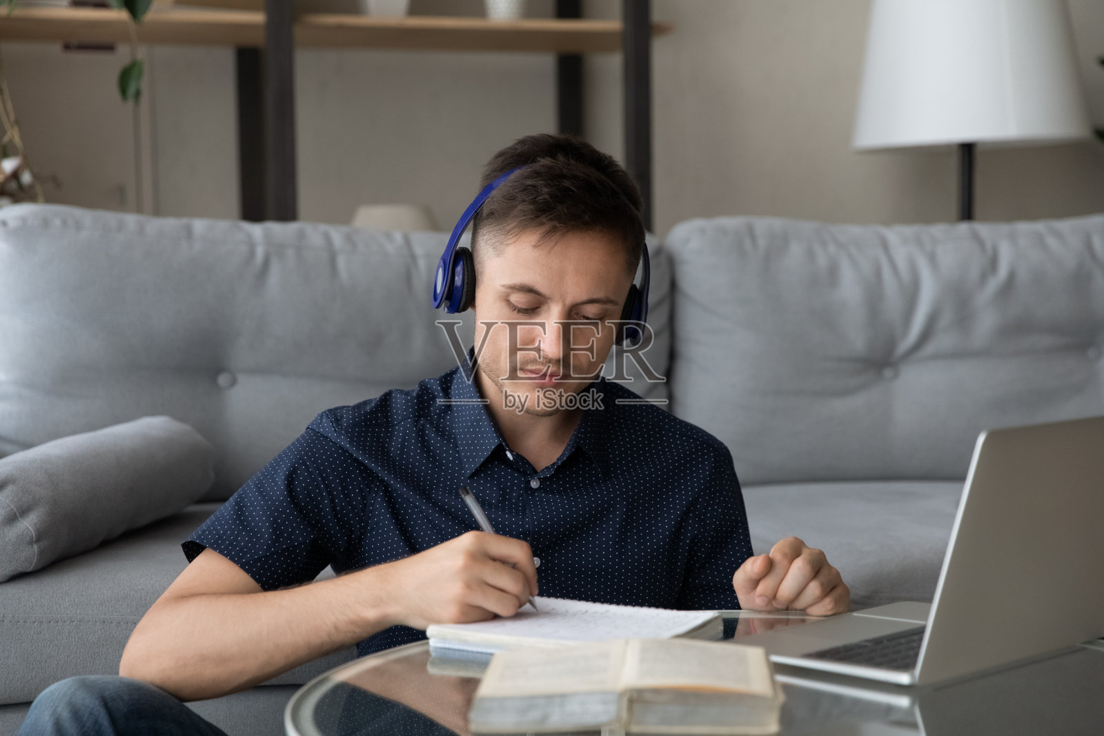 专注的年轻学生戴着无线耳机照片摄影图片